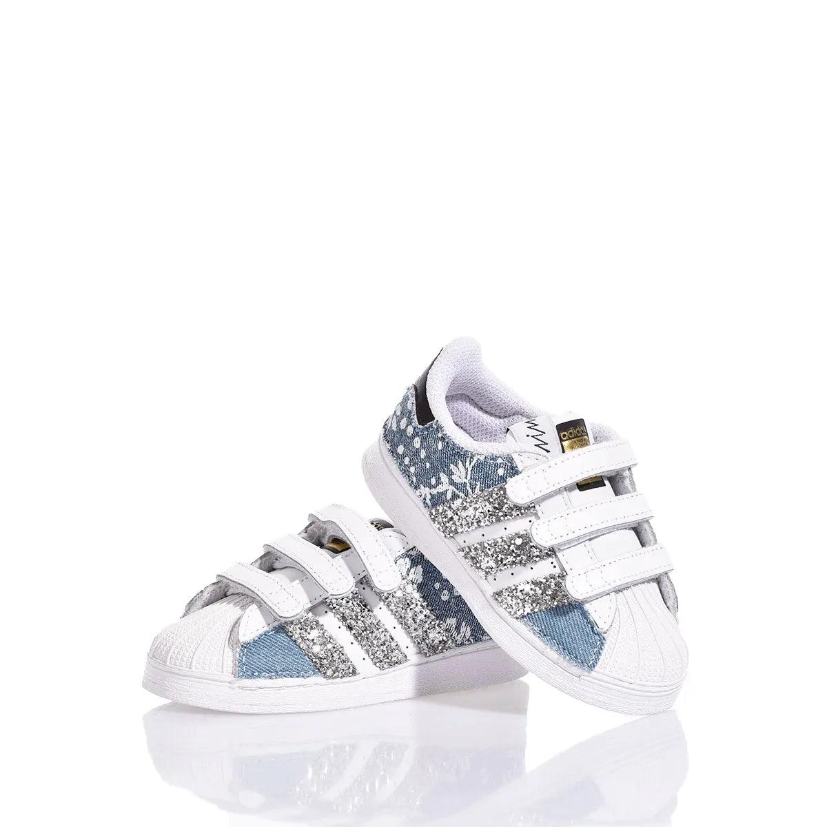 Scarpe da ginnastica bambino bianche con glitter argento e dettagli azzurri su sfondo bianco