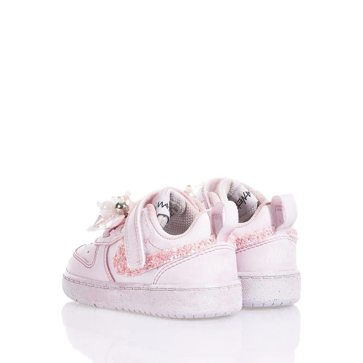 Scarpe sportive neonata rosa con dettagli glitterati e fiocchi decorativi, fondo bianco
