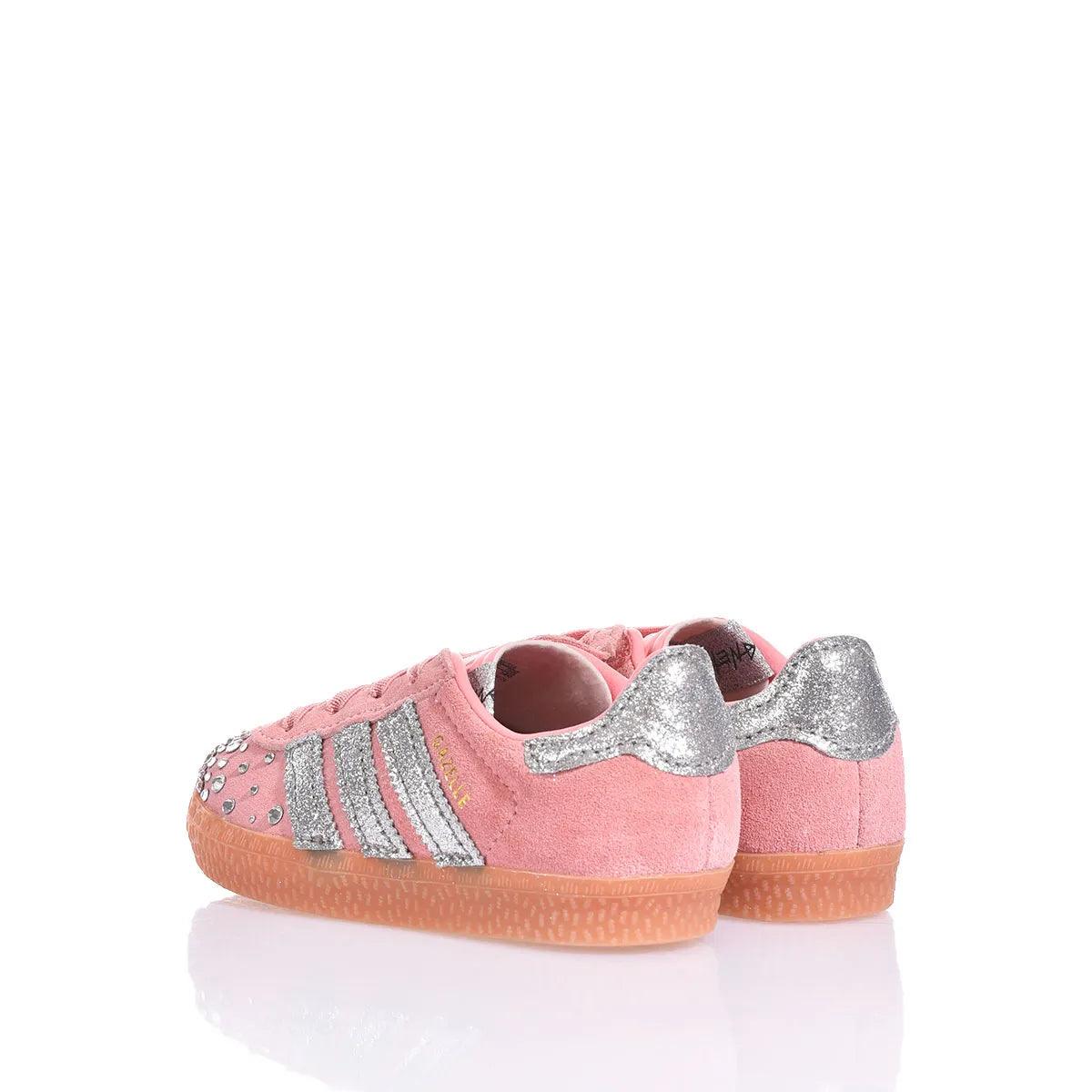 Sneakers rosa in suede con dettagli glitter argento, strisce laterali e borchie decorative.