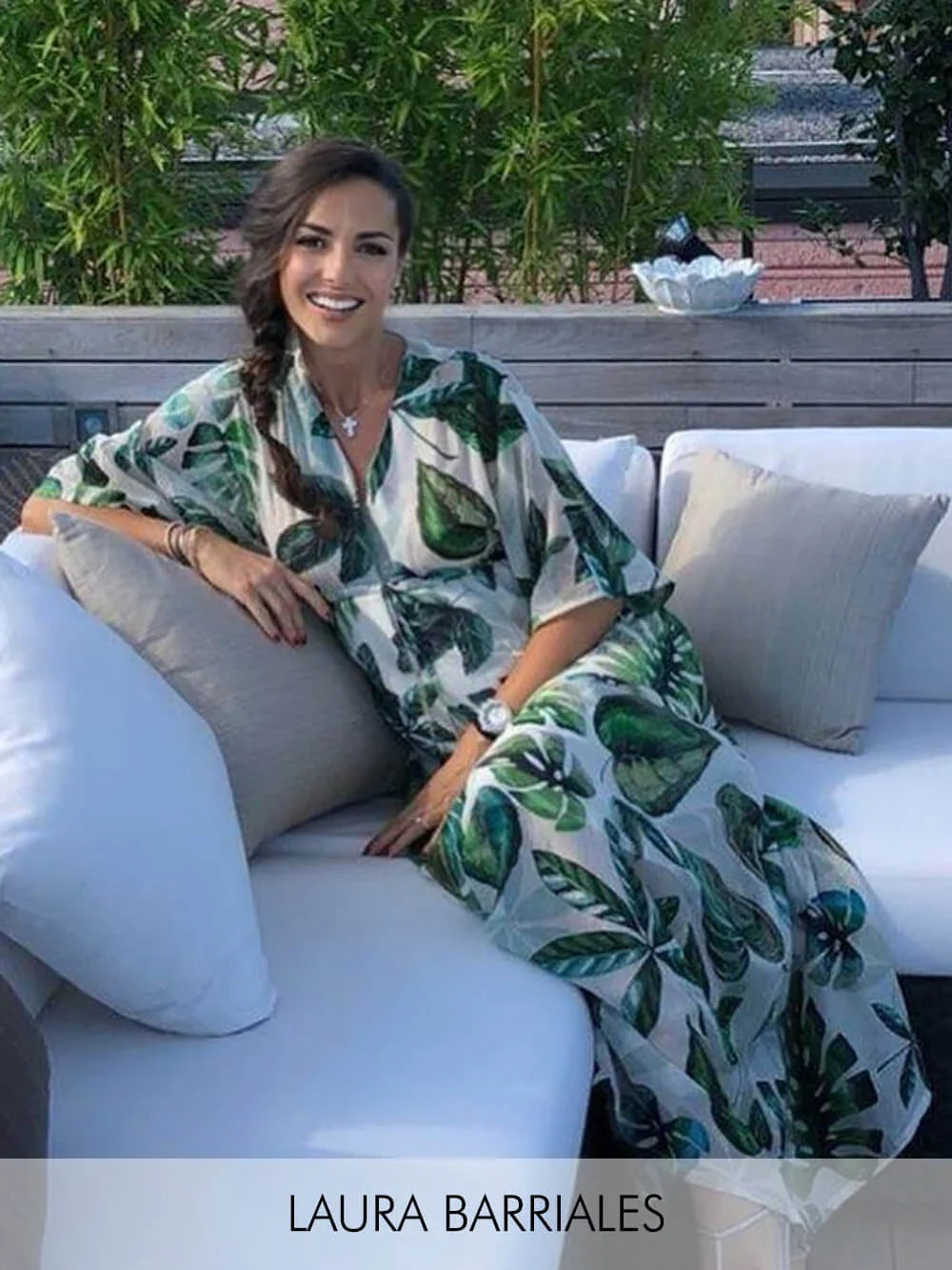 Donna che indossa un abito premaman lungo con stampa tropicale verde e bianca.