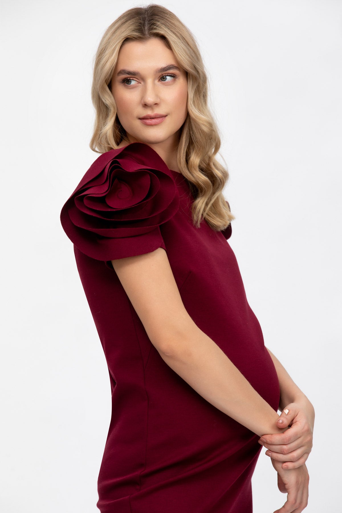 Donna incinta con abito premaman elegante bordeaux, manica con dettaglio floreale