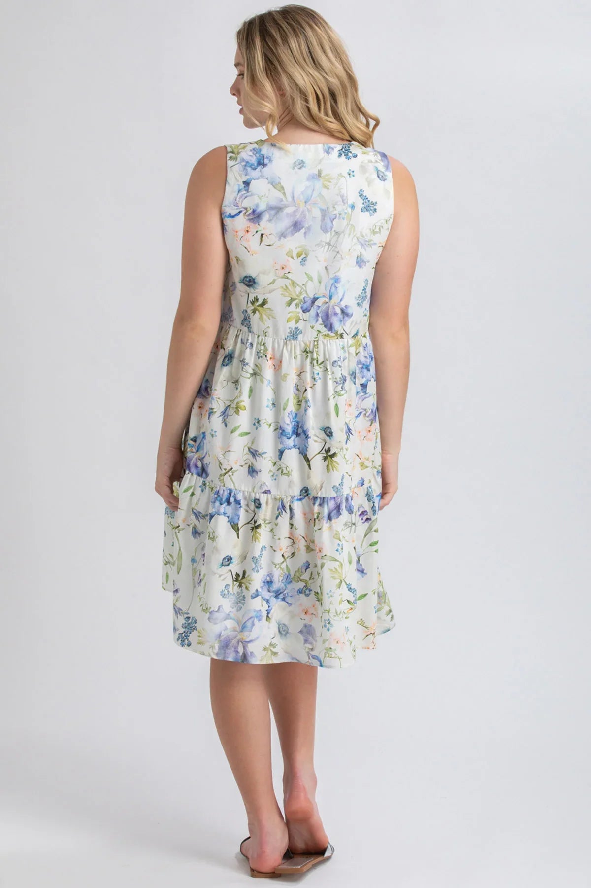 Abito premaman smanicato floreale bianco e azzurro, donna di spalle, stile casual.