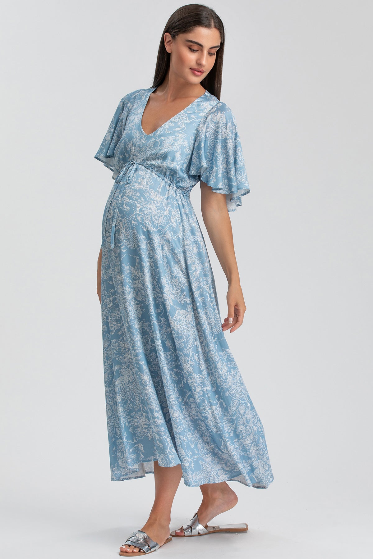 Abito premaman elegante azzurro con fantasia floreale, maniche corte e scollo a V.