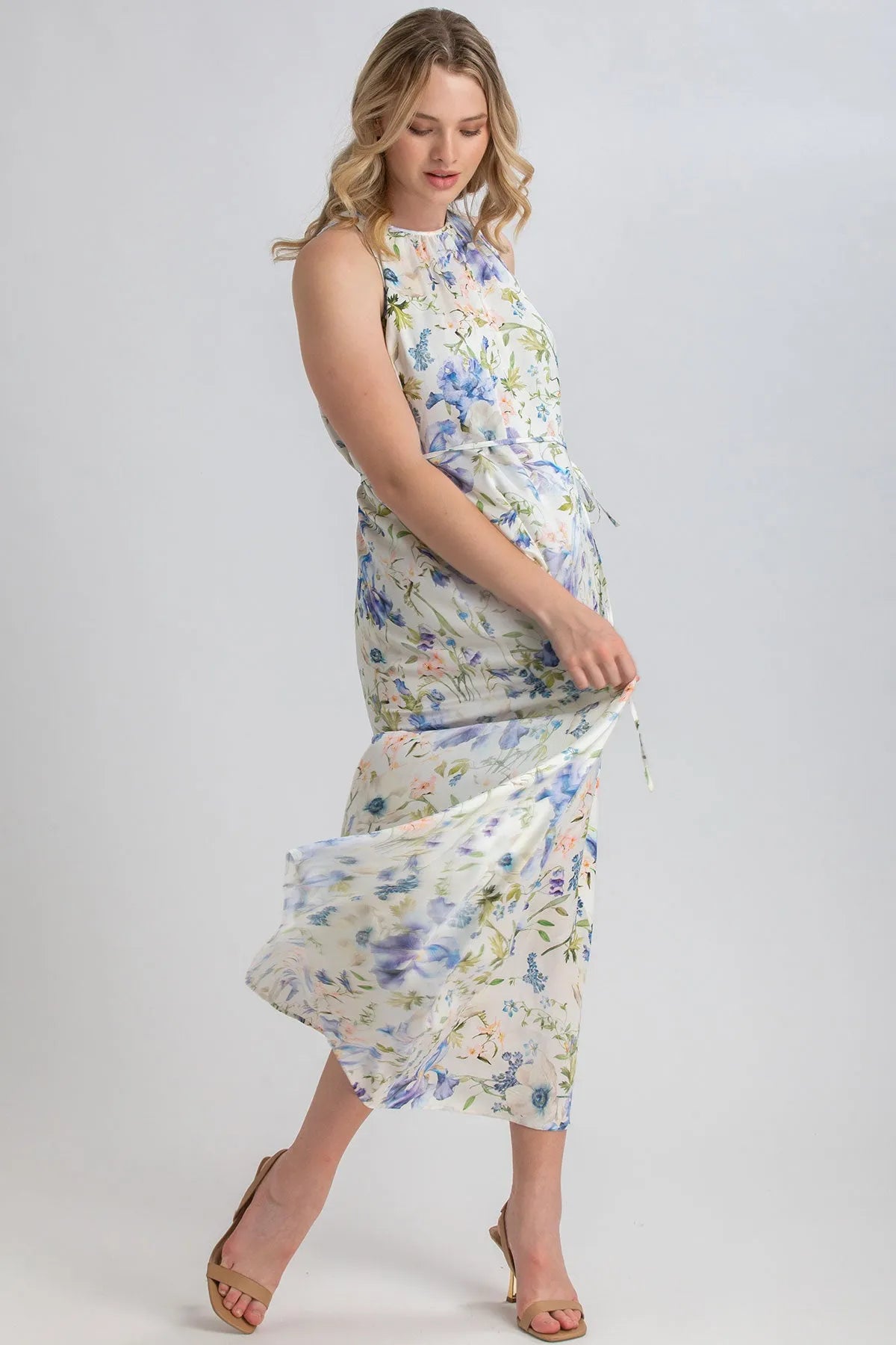 Donna incinta con abito premaman lungo floreale smanicato, tessuto leggero elegante.