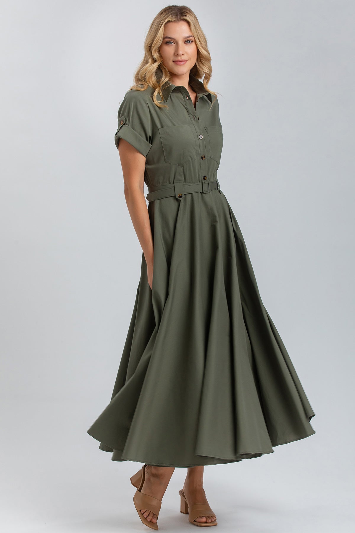 Donna indossa abito premaman verde militare con cintura, maniche corte e gonna ampia.