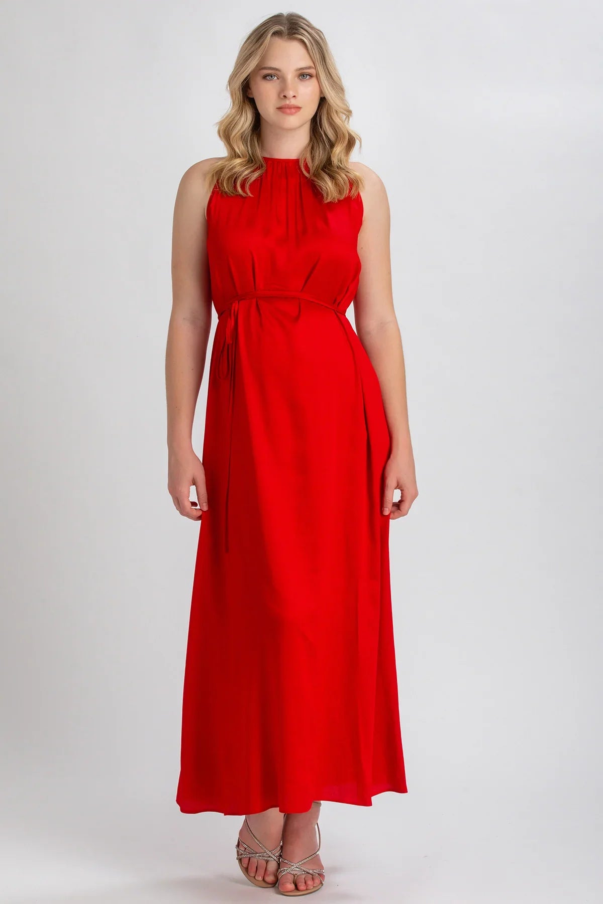 Donna indossa abito premaman lungo rosso senza maniche, elegante e confortevole.