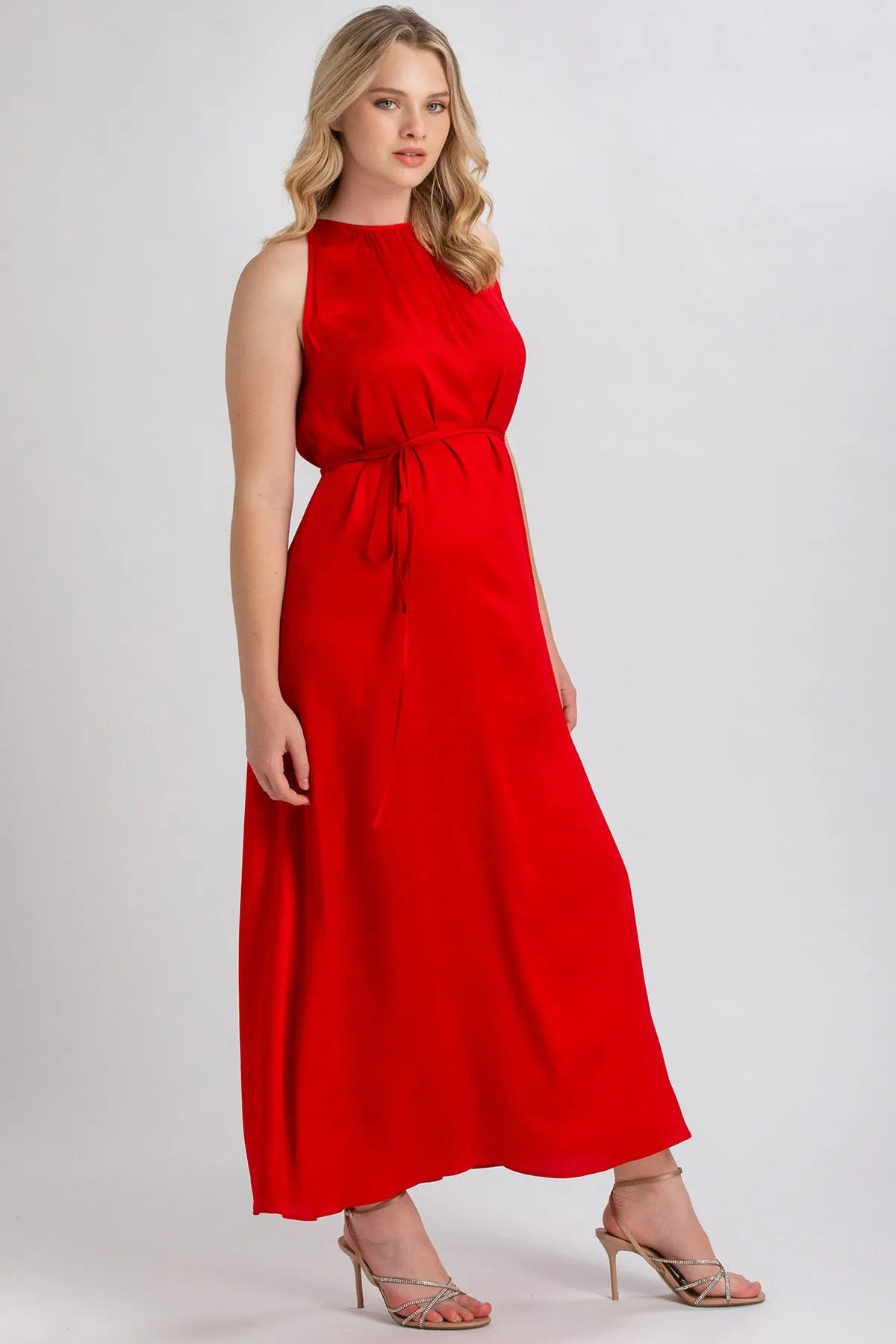 Donna in abito premaman lungo rosso senza maniche, vestibilità elegante e confortevole.
