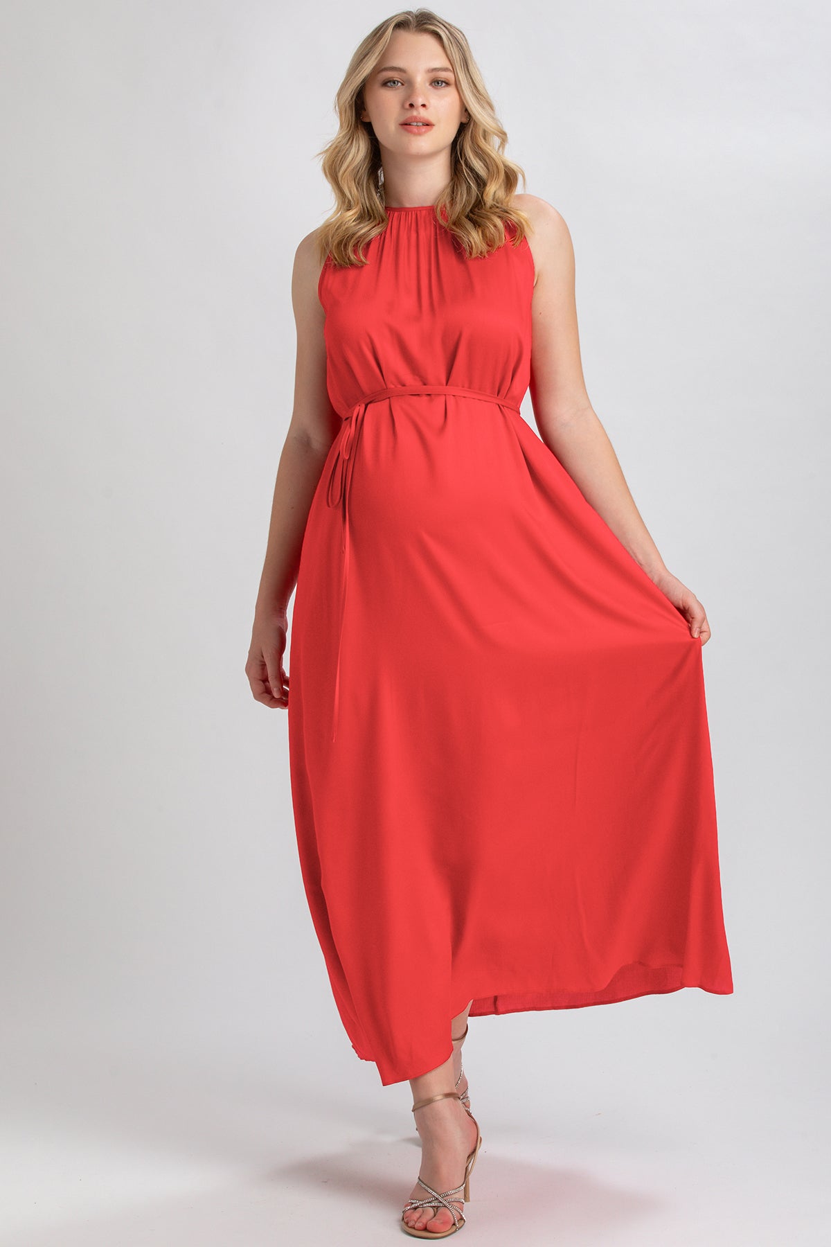 Abito premaman lungo rosso senza maniche elegante, indossato da donna incinta