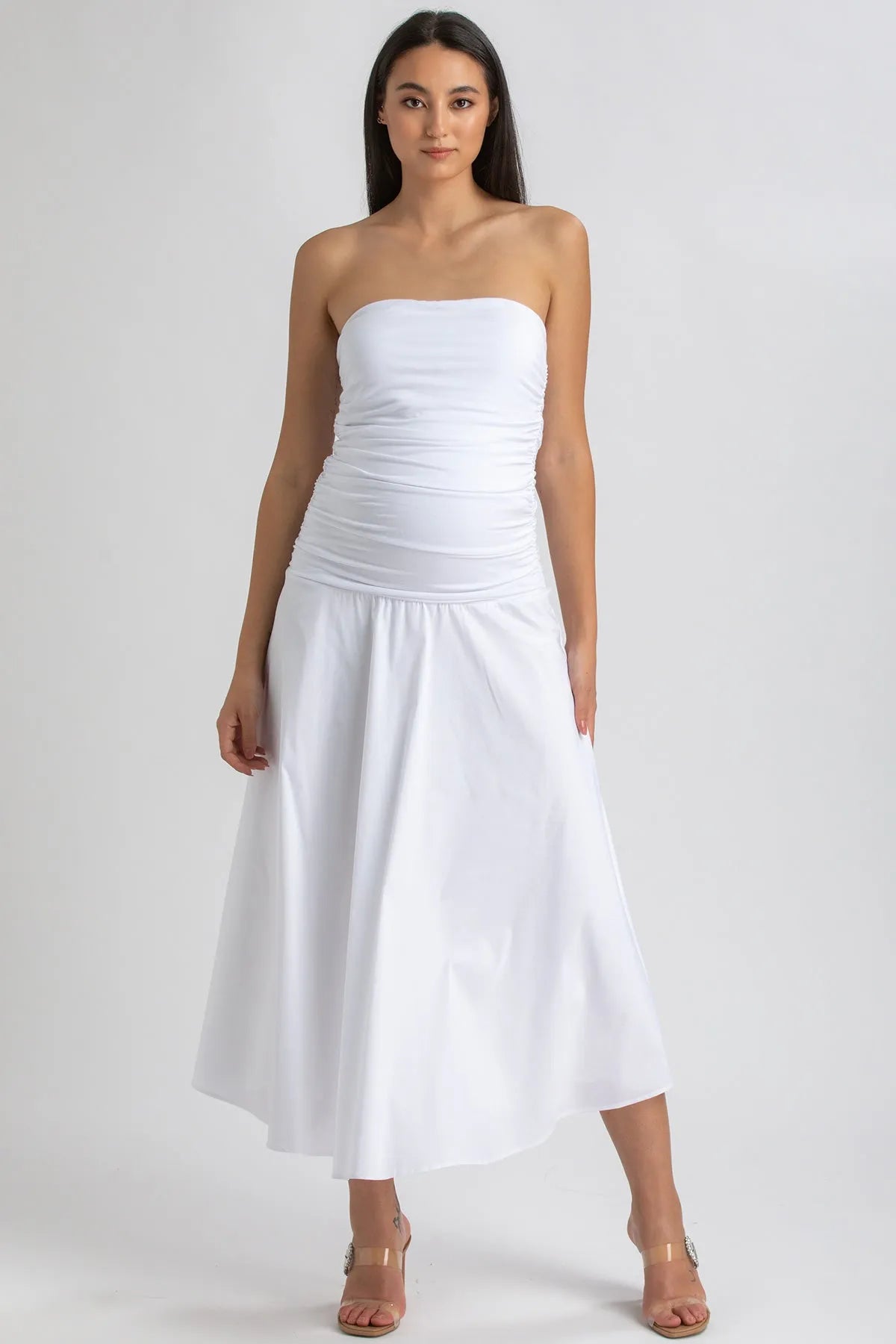 Donna indossa abito premaman bianco lungo senza spalline elegante e confortevole.