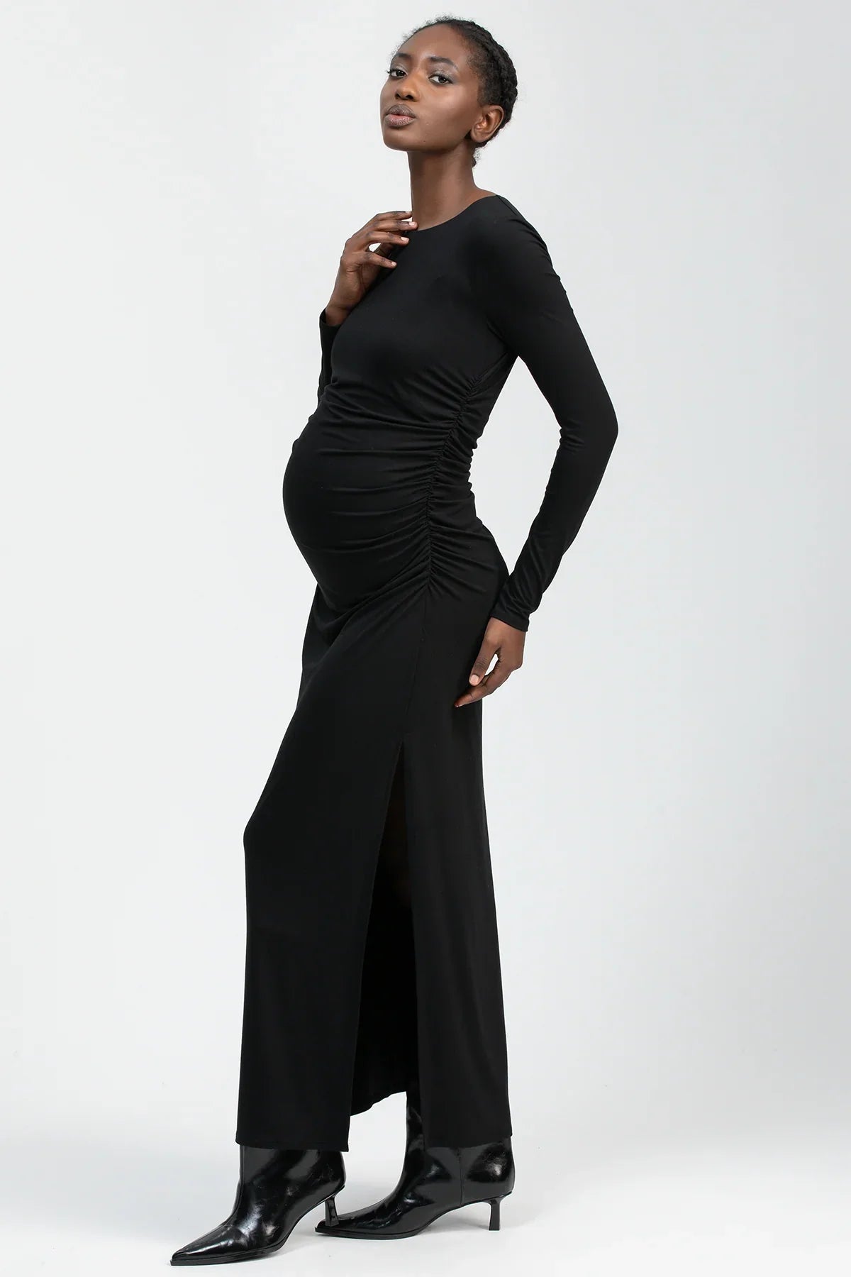 Fitted black maternity maxi dress featuring a round neckline and elegant side slit.