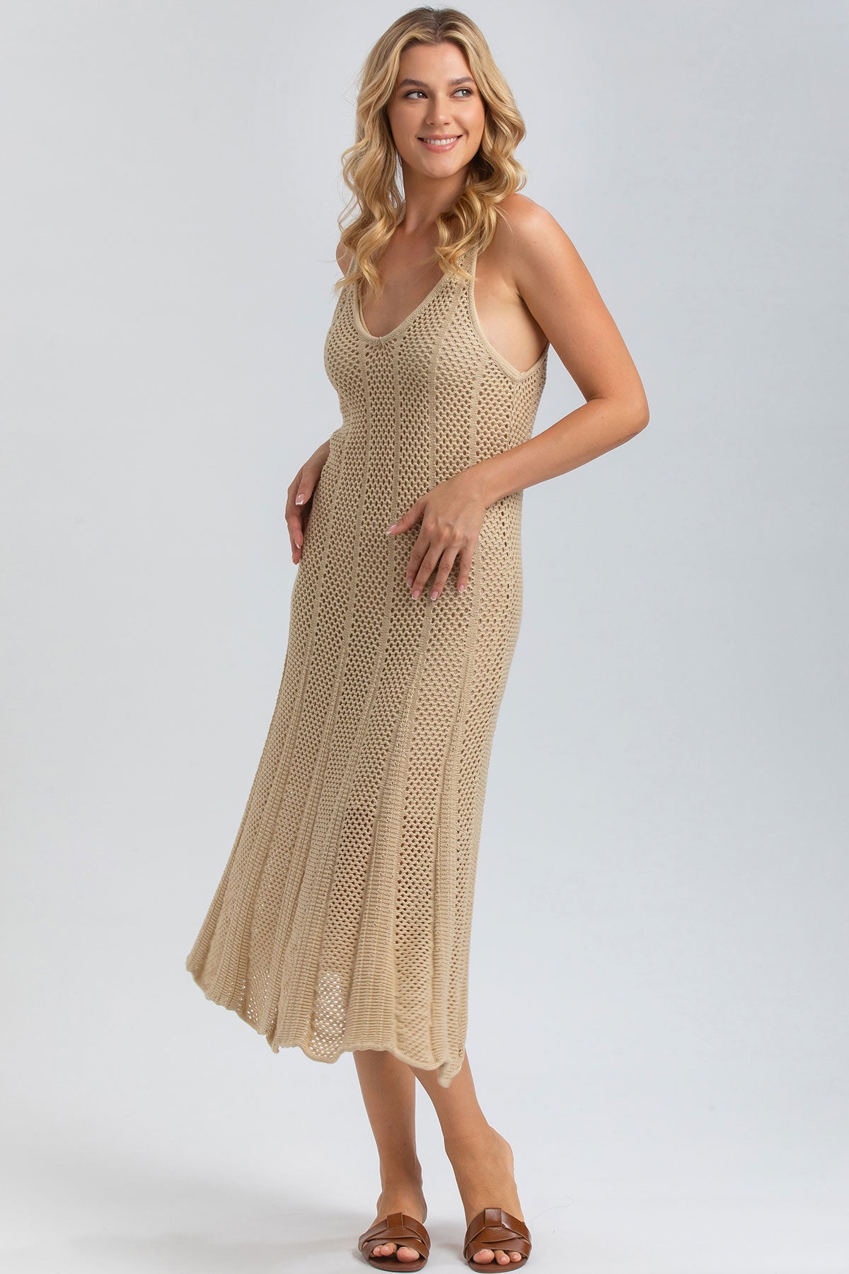 Abito premaman beige in maglia traforata senza maniche, vestibilità comoda ed elegante.