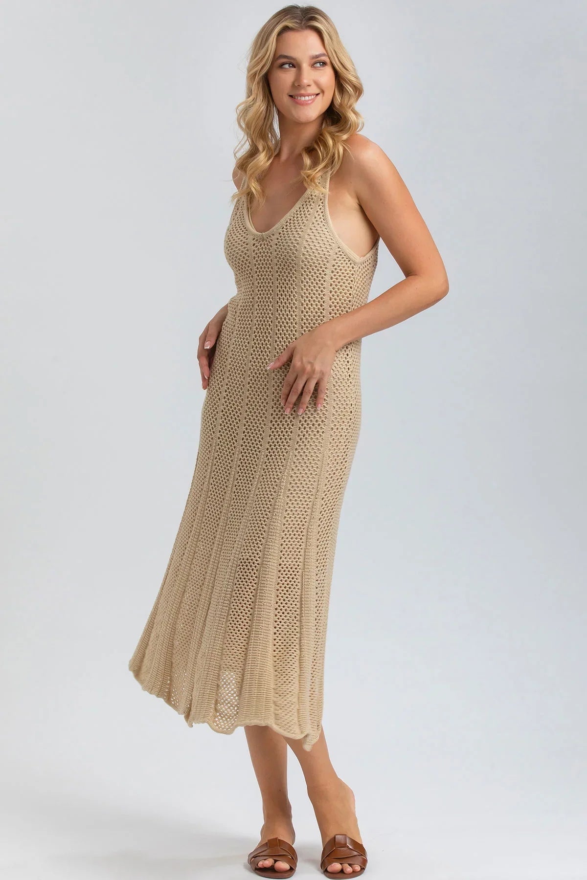 Abito premaman beige in maglia traforata senza maniche, vestibilità comoda ed elegante.