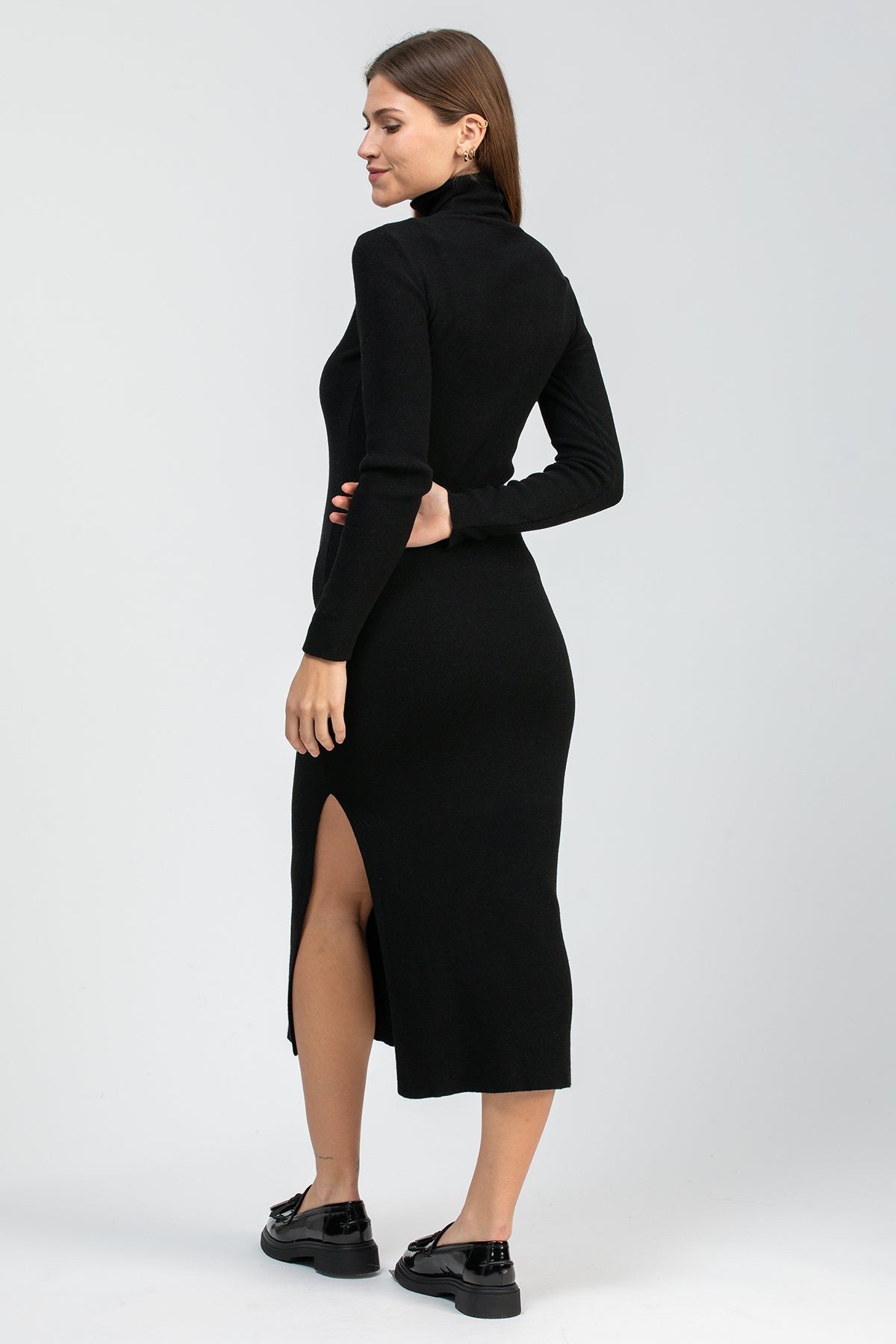 Vestito premaman nero a maniche lunghe con collo alto e spacco posteriore, indossato da donna
