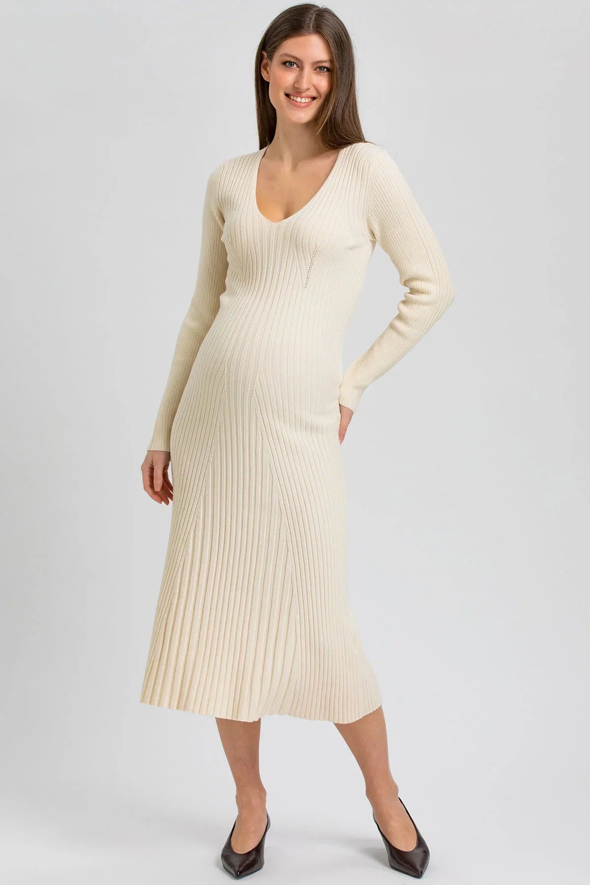 Abito premaman crema lungo in maglia a costine, con scollo a V e linea svasata. Elegante, femminile e confortevole.