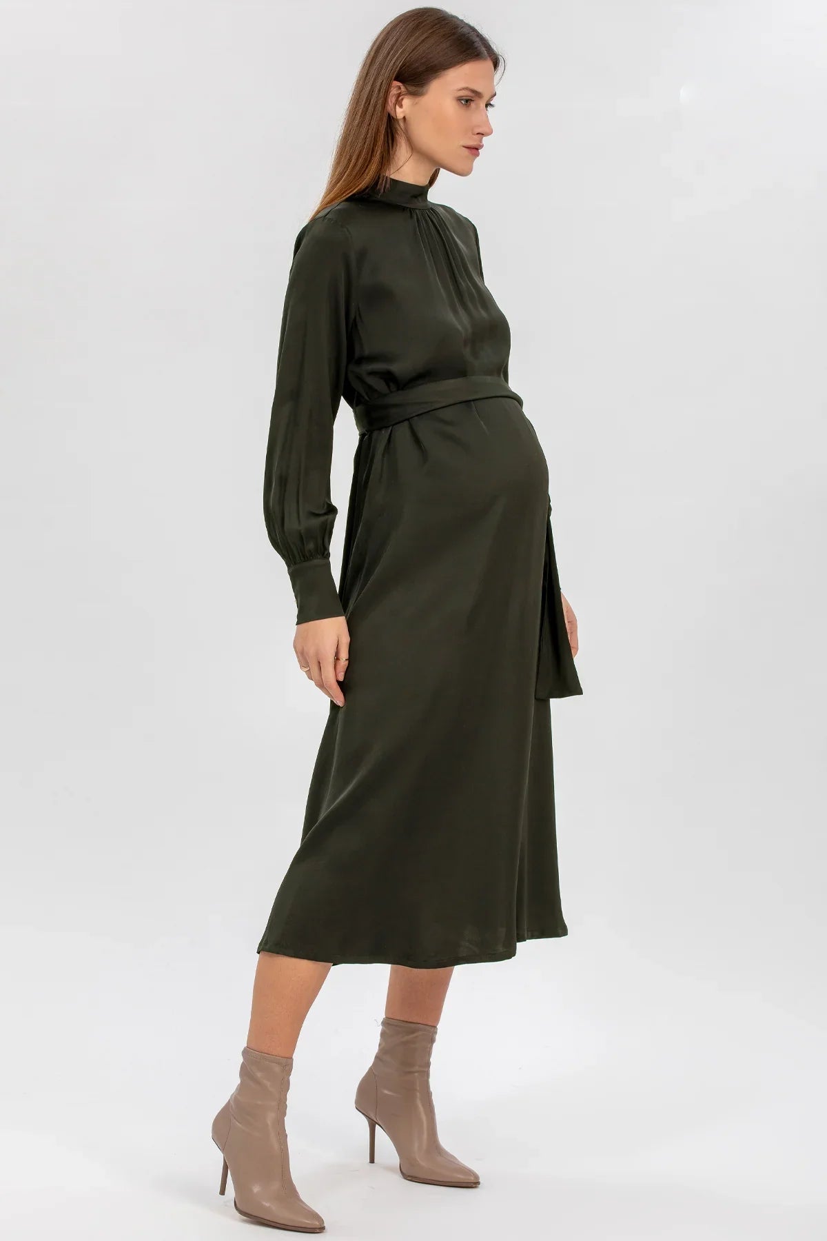 Donna incinta indossa abito premaman elegante verde scuro a maniche lunghe