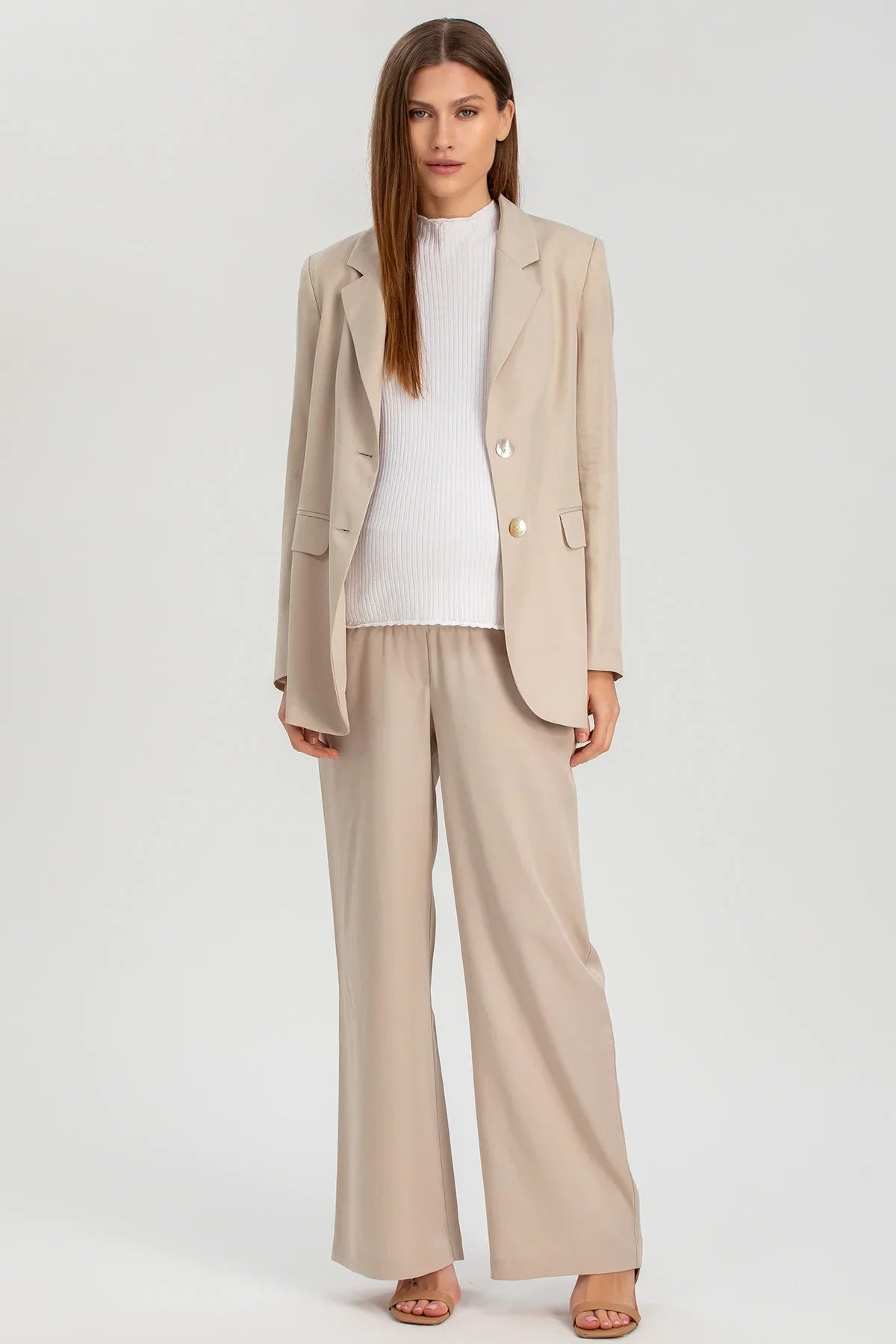Completo premaman elegante beige con blazer e pantaloni ampi, maglia bianca, stile business casual.