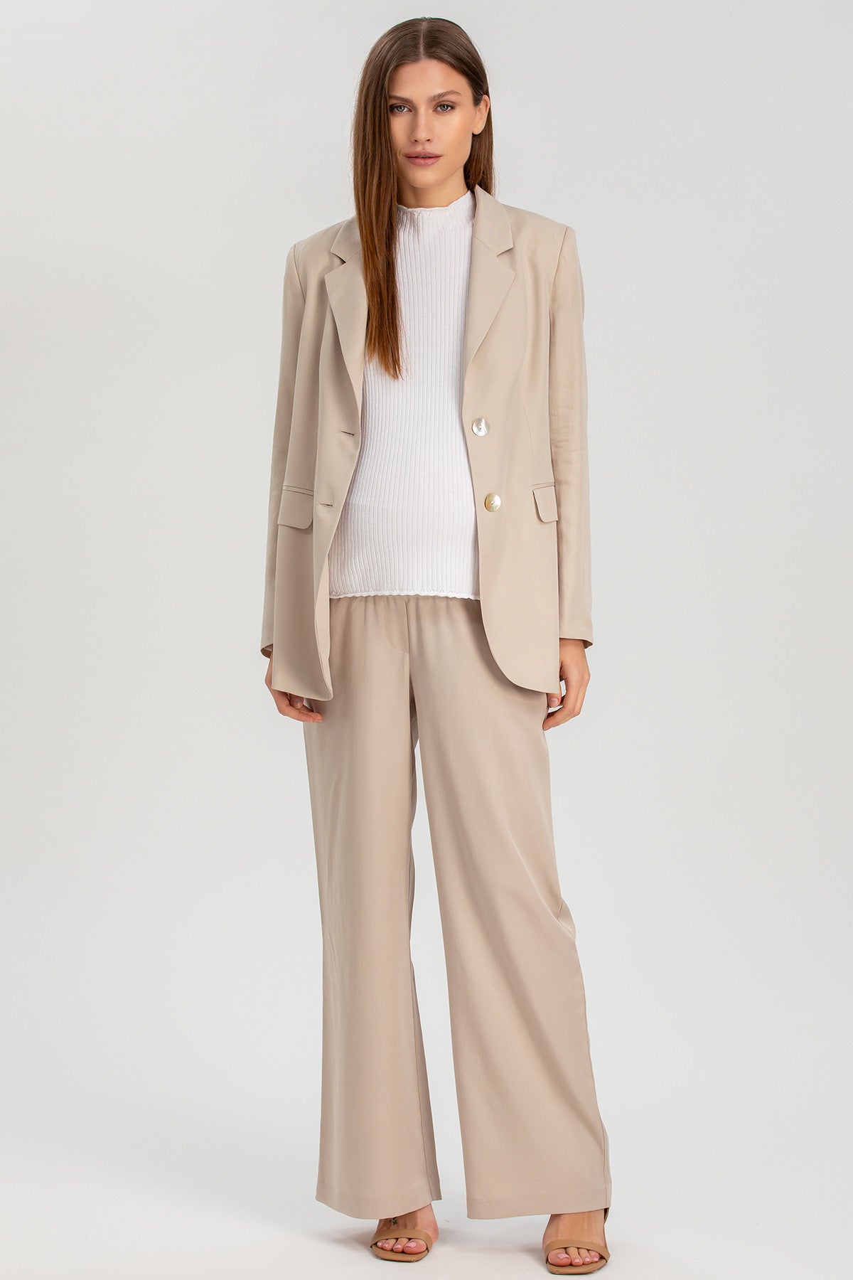 Completo premaman elegante beige con blazer e pantaloni ampi, maglia bianca, stile business casual.