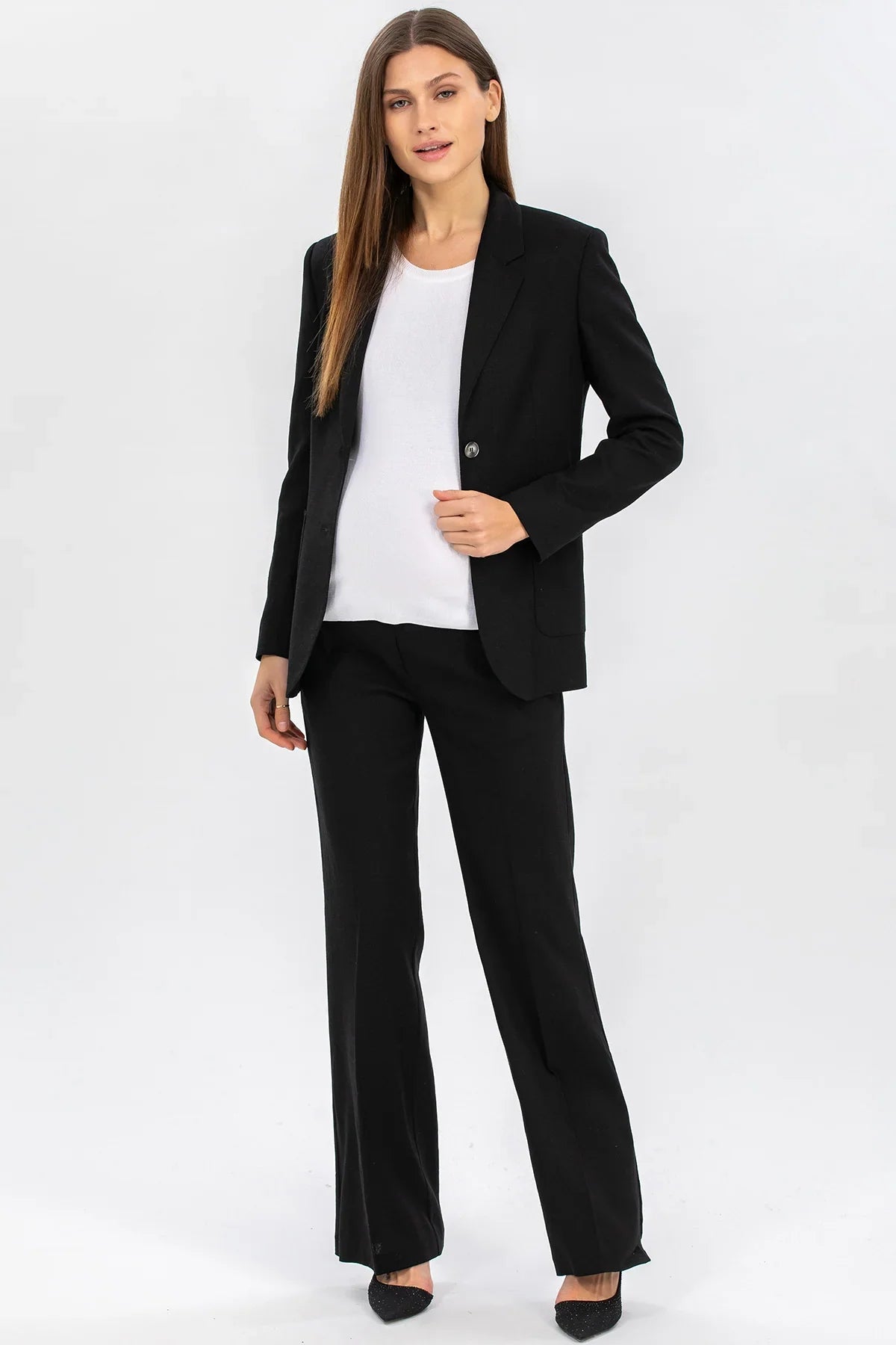 Donna indossa completo premaman elegante nero con blazer e pantalone in tessuto pregiato