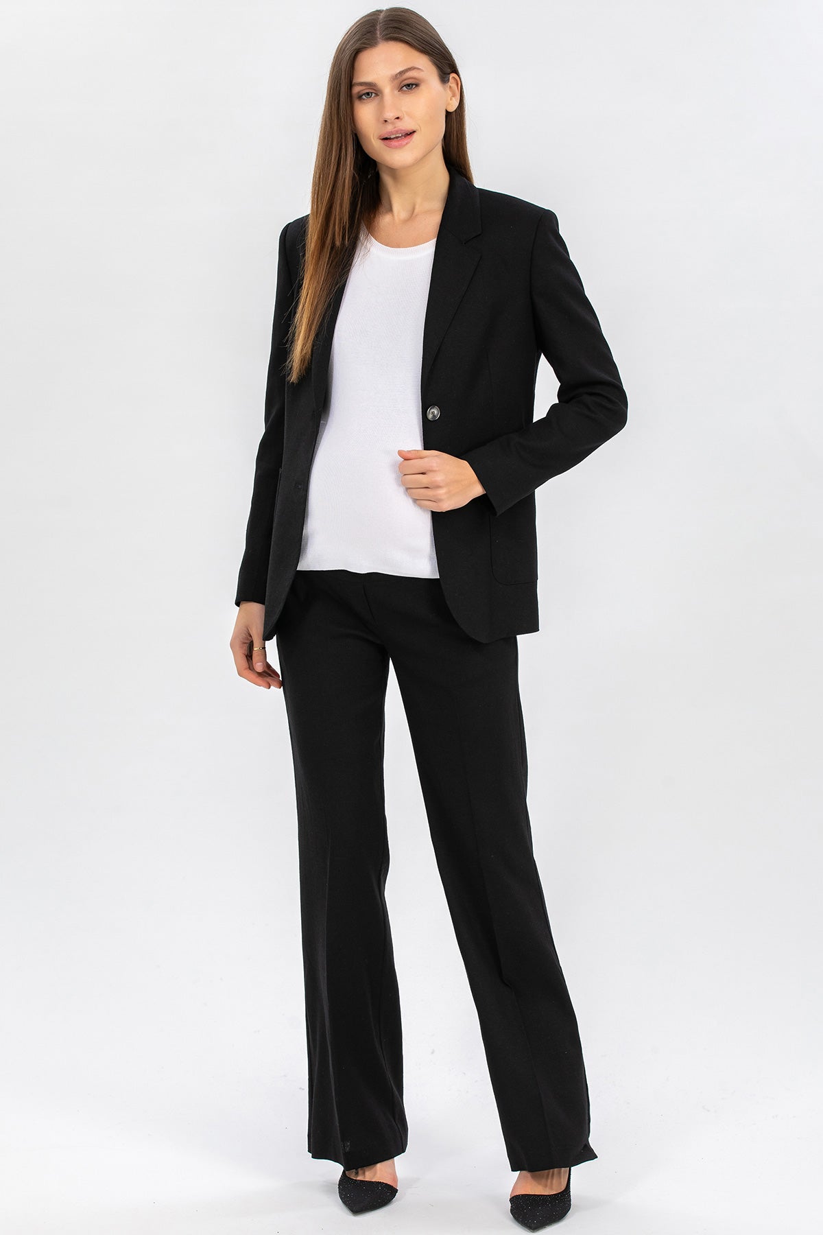 Donna indossa completo premaman elegante nero con blazer e pantalone in tessuto pregiato