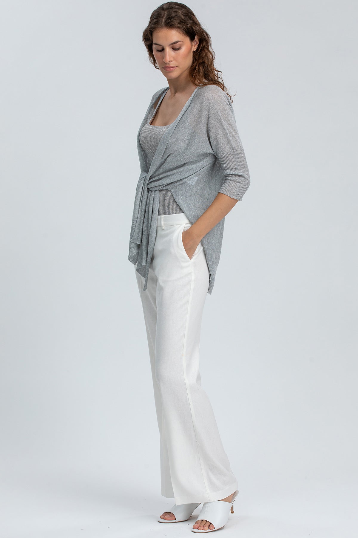 Abbigliamento premaman elegante, donna con maglia grigia e pantaloni bianchi larghi