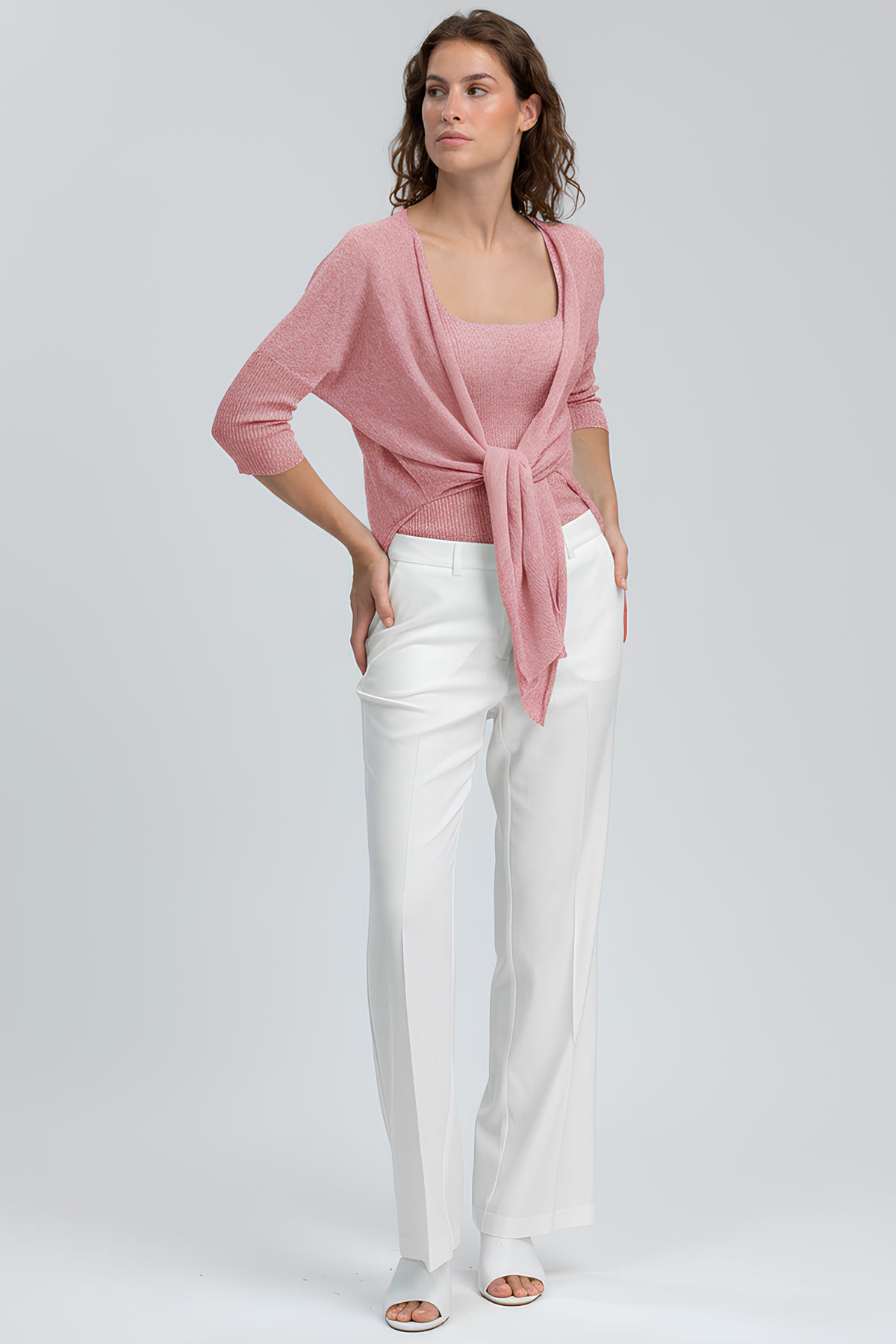 Completo premaman elegante con maglia rosa intrecciata e pantaloni bianchi larghi