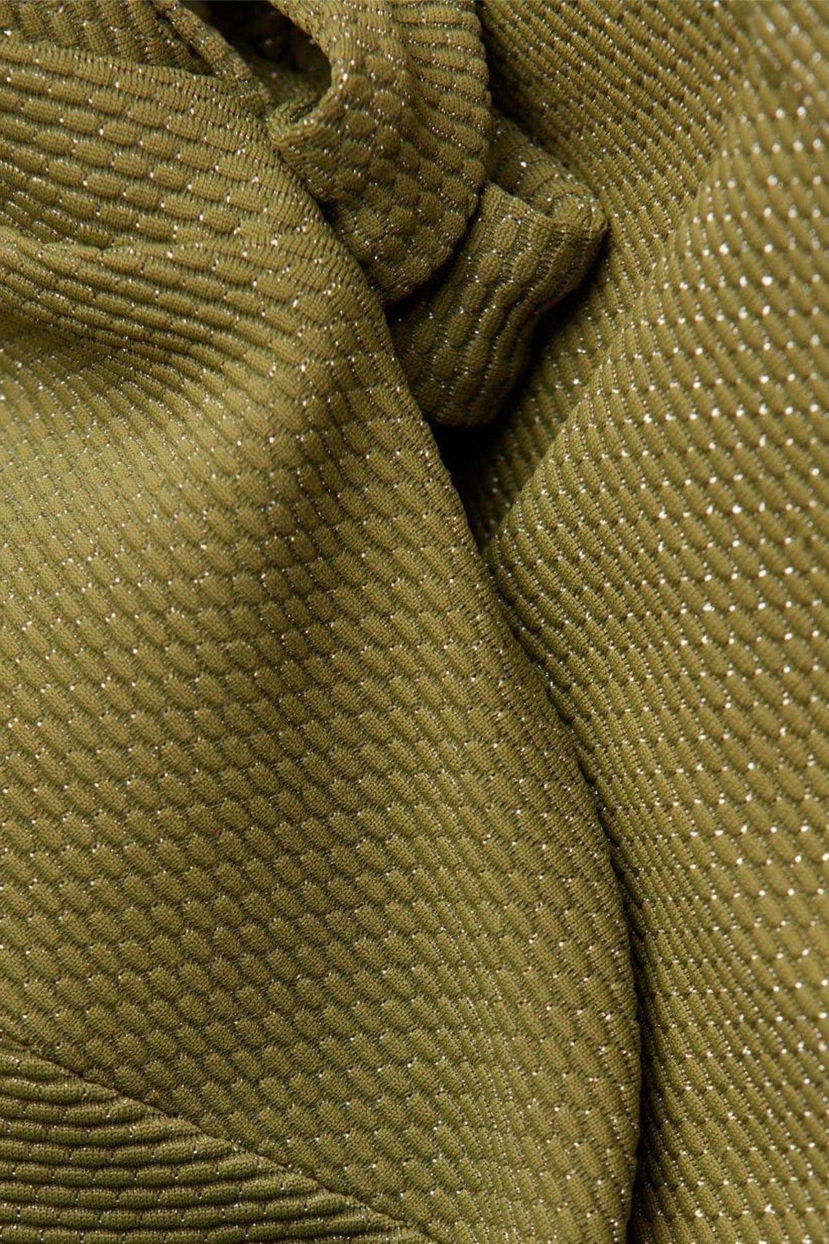 Dettaglio tessuto premaman verde oliva a trama strutturata con fili lucenti