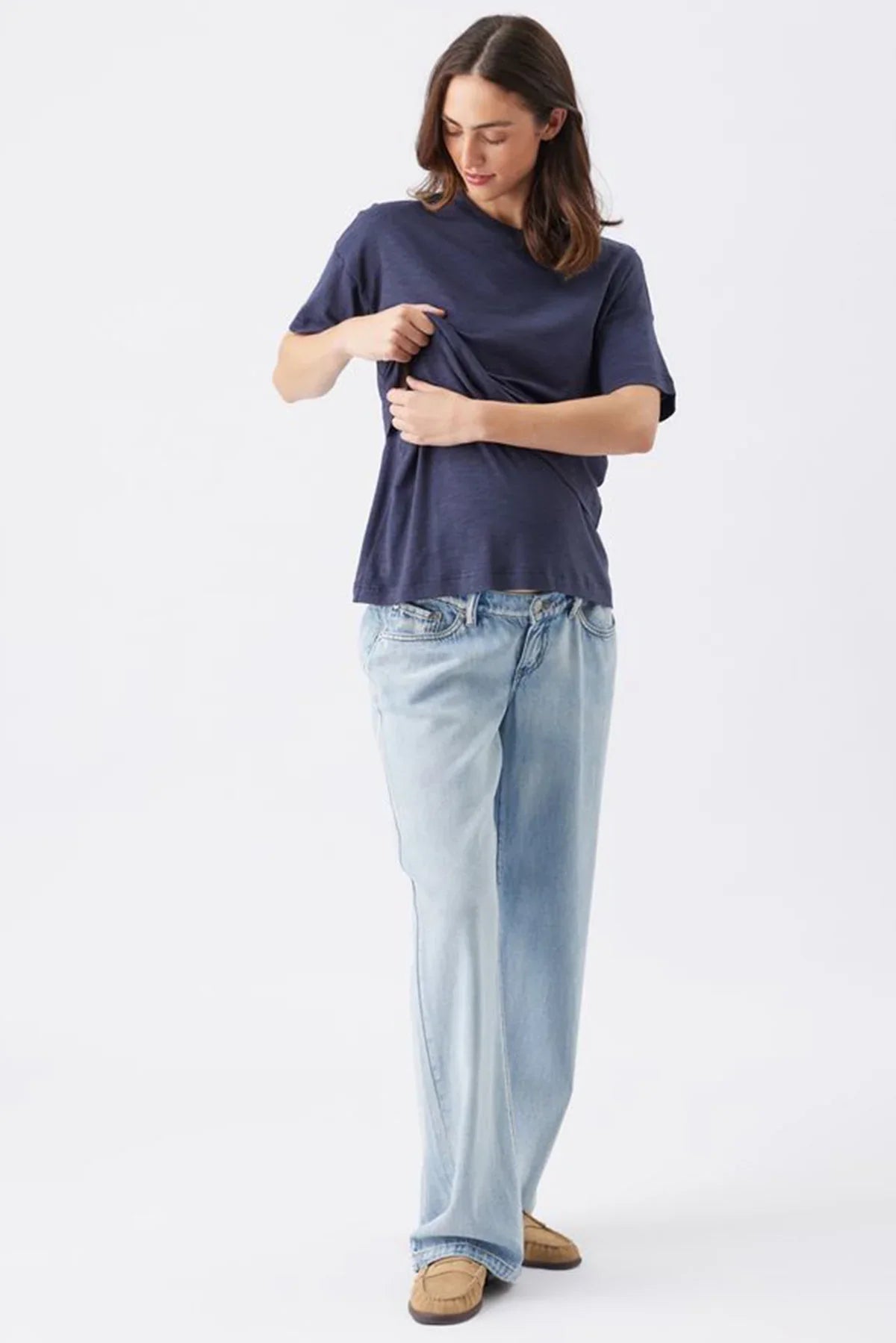 Donna con maglia premaman e allattamento blu scuro Ripe e jeans premaman chiari.