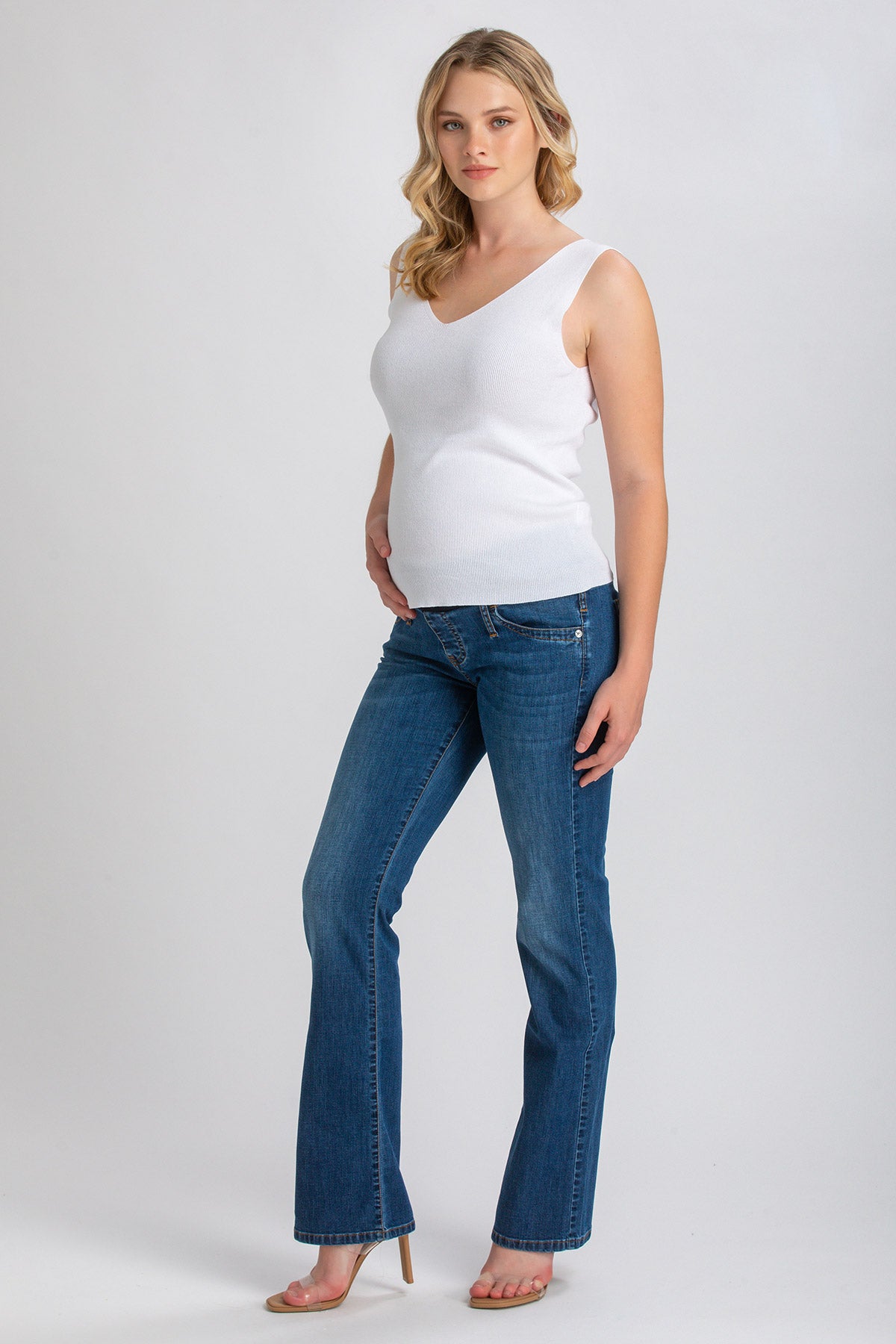 Jeans premaman slim bootcut blu, indossati da donna in gravidanza su sfondo neutro