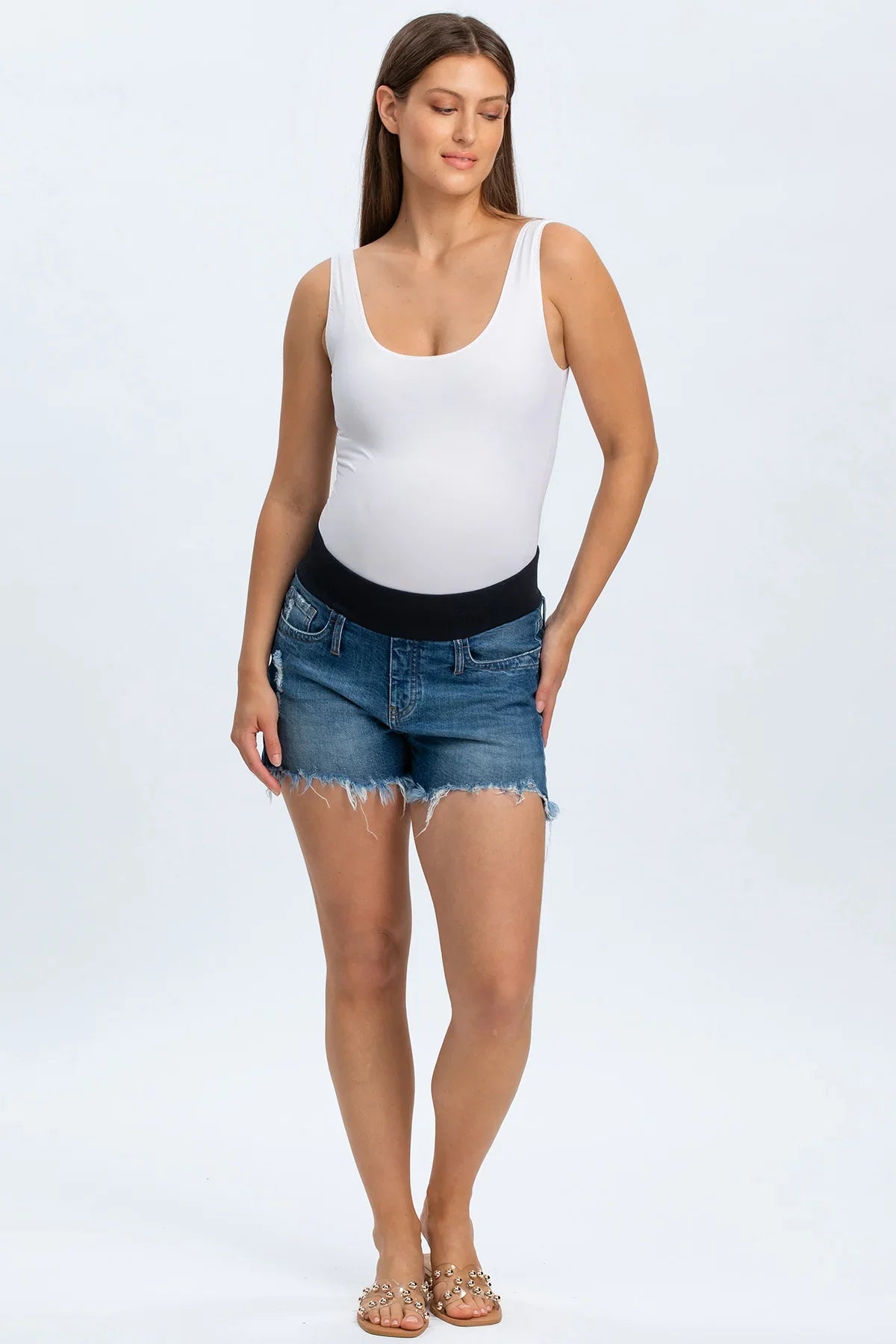 Shorts premaman in denim con fascia elastica nera e bordo sfrangiato, indossati da donna incinta.