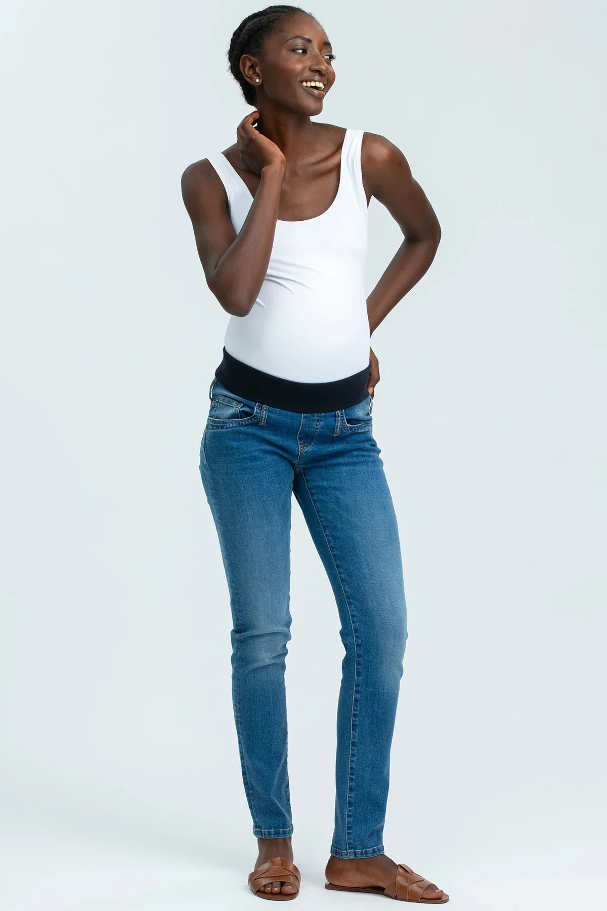 Modella indossa jeans premaman elasticizzati e top bianco, abbigliamento premaman casual