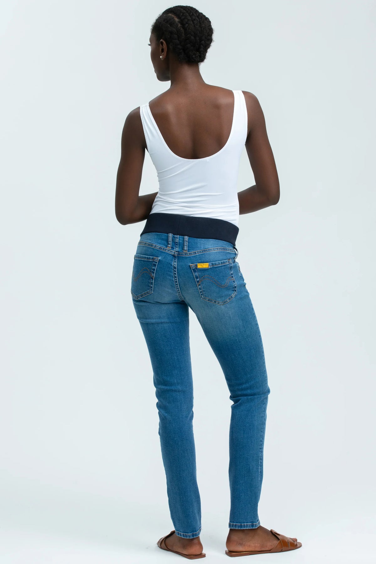 Jeans premaman elasticizzati blu con fascia in vita, indossati da donna su sfondo chiaro
