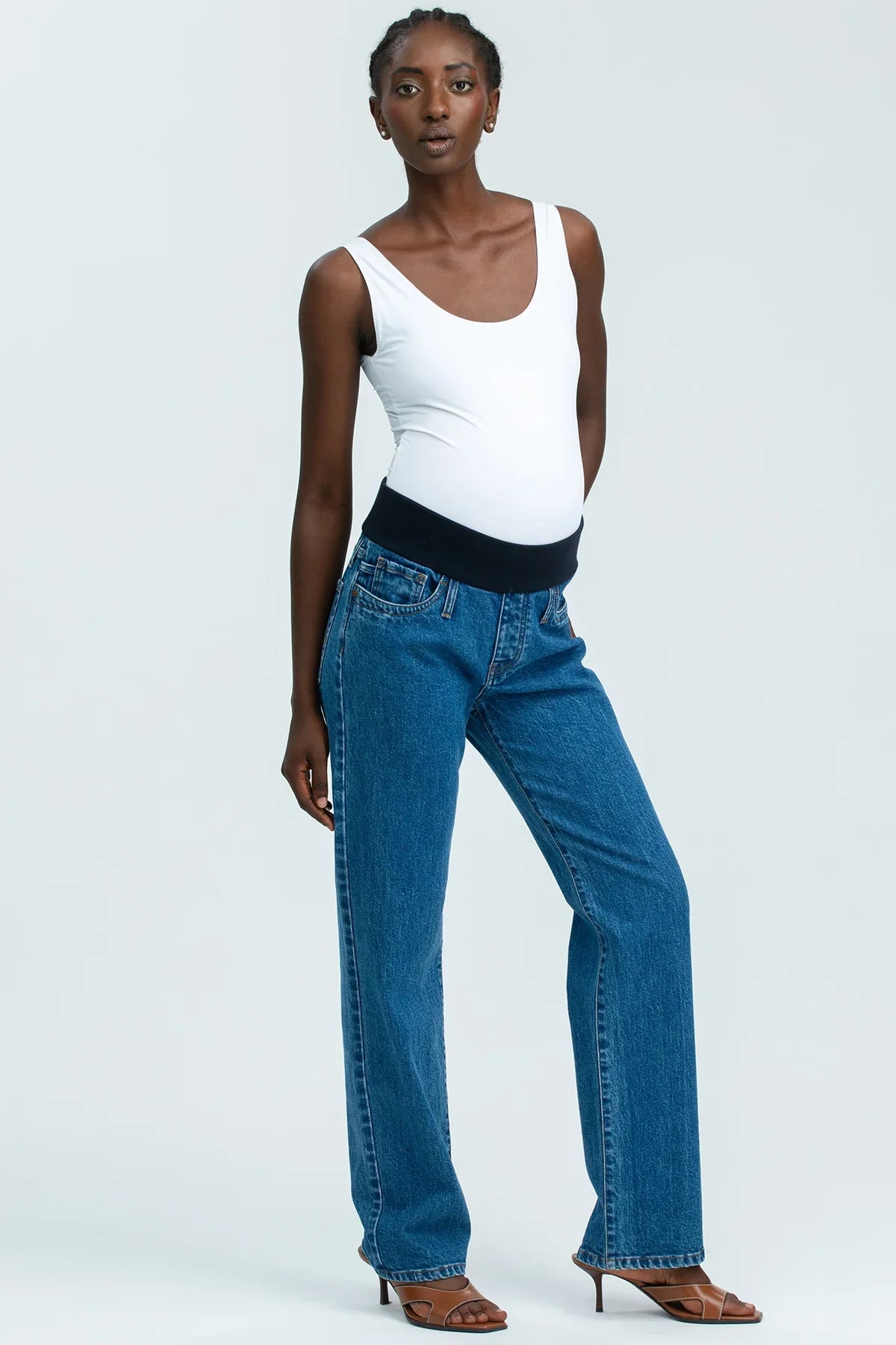 Model wearing high-waisted straight-leg maternity jeans with a comfortable stretchy belly band, styled for an elegant maternity look.
