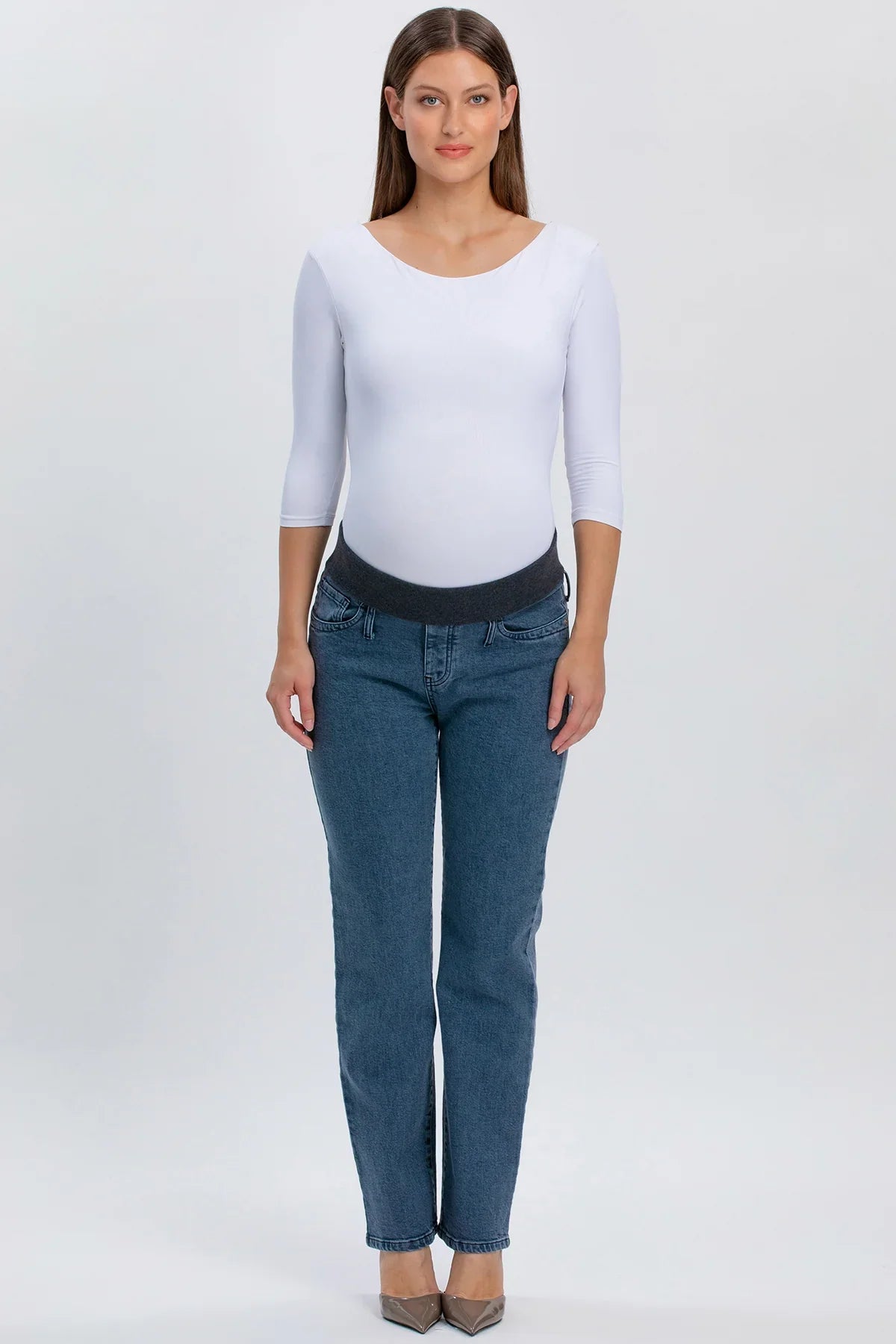 Donna incinta con jeans premaman grigi a gamba dritta e fascia elastica, maglia bianca