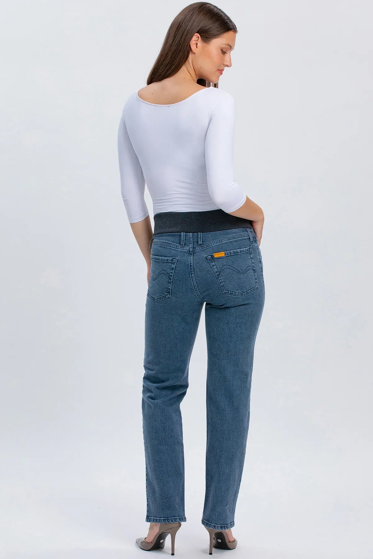 Modella indossa jeans premaman grigi a gamba dritta con fascia elastica nera.