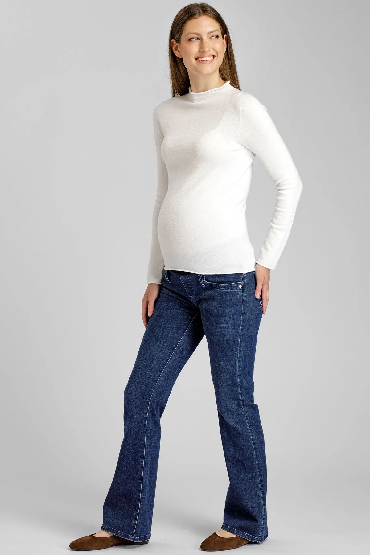 Donna con maglia premaman bianca a maniche lunghe e jeans premaman blu Pietro Brunelli Maternity