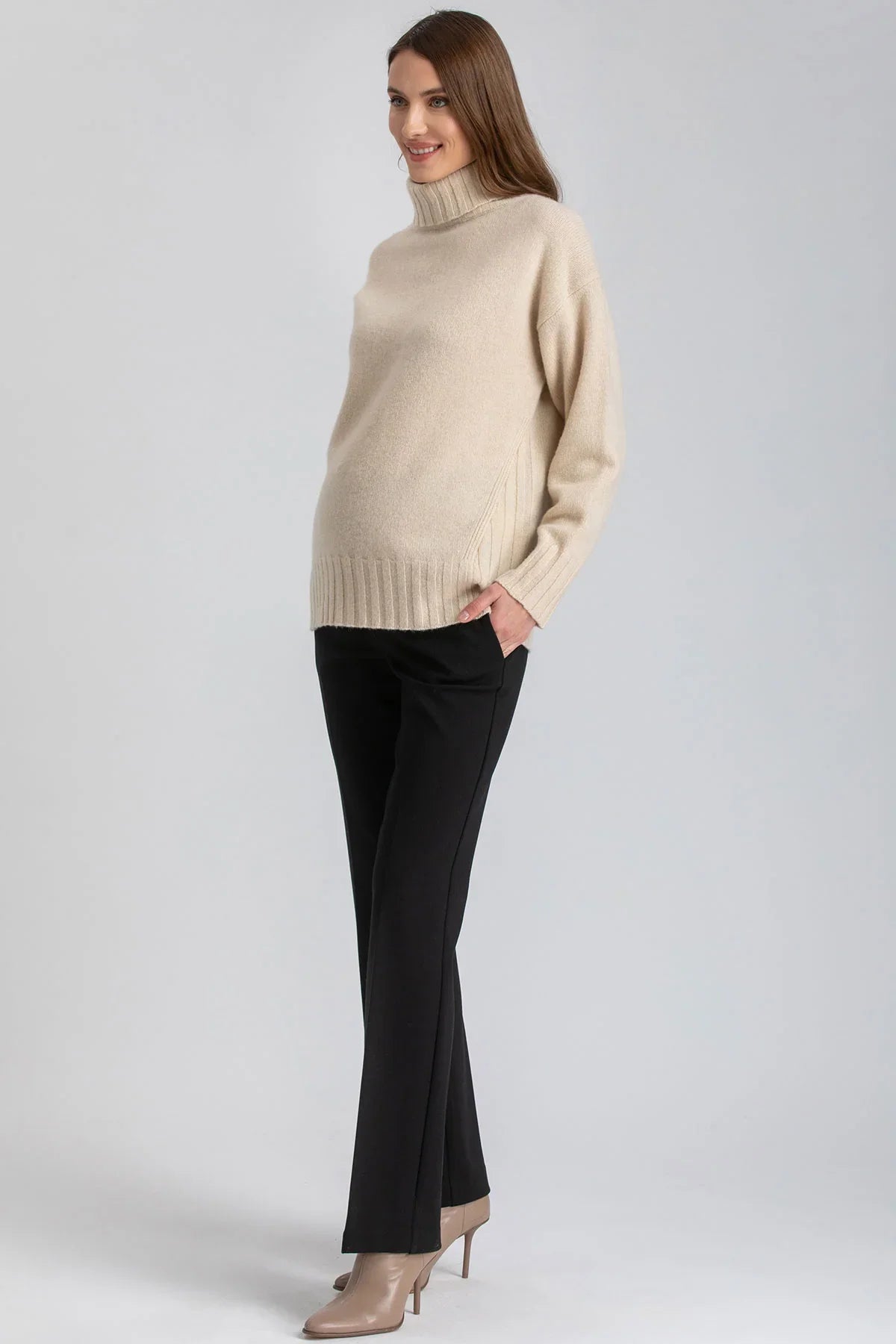 Donna con maglione beige e pantaloni premaman neri a gamba dritta di Pietro Brunelli Maternity