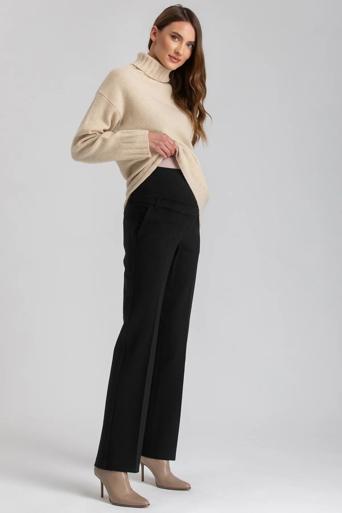 Donna con pantaloni premaman neri a gamba dritta e maglia beige di Pietro Brunelli Maternity