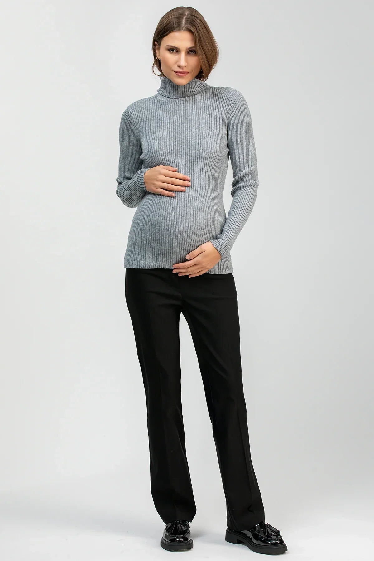 Maglione premaman grigio a coste con pantaloni neri eleganti, look gravidanza moderno.