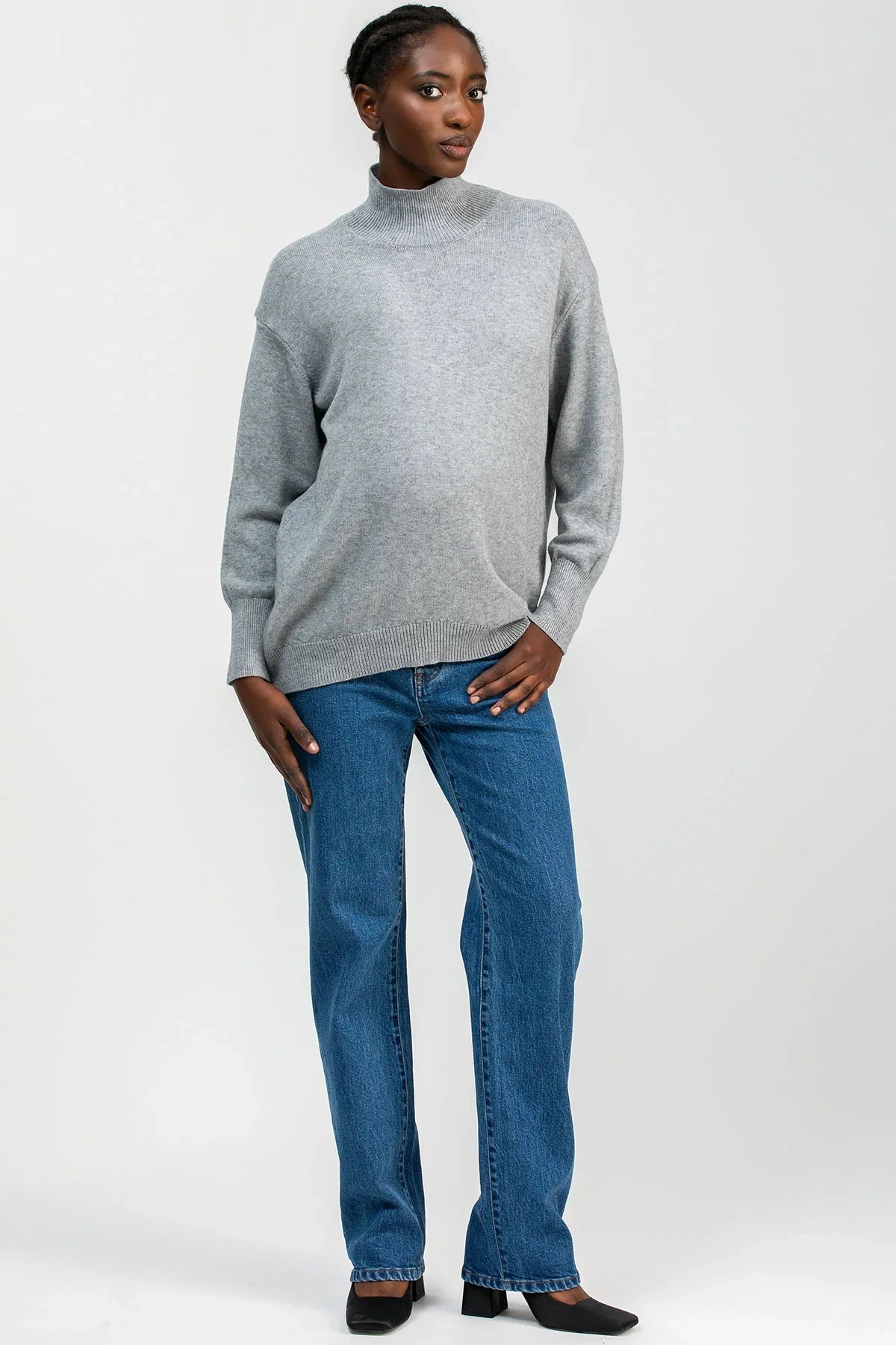 Modella indossa jeans premaman dritti a vita alta con fascia elastica comoda, abbigliamento premaman elegante.