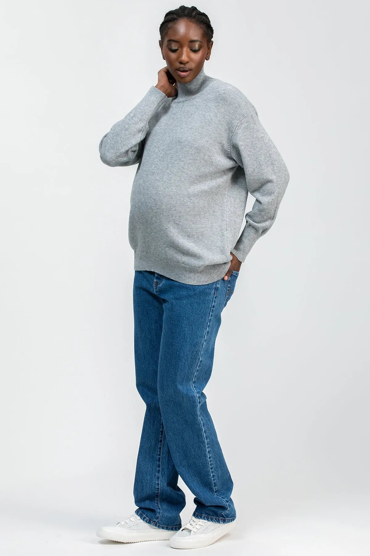Donna con maglia premaman grigia collo a lupetto e jeans premaman di Pietro Brunelli Maternity.