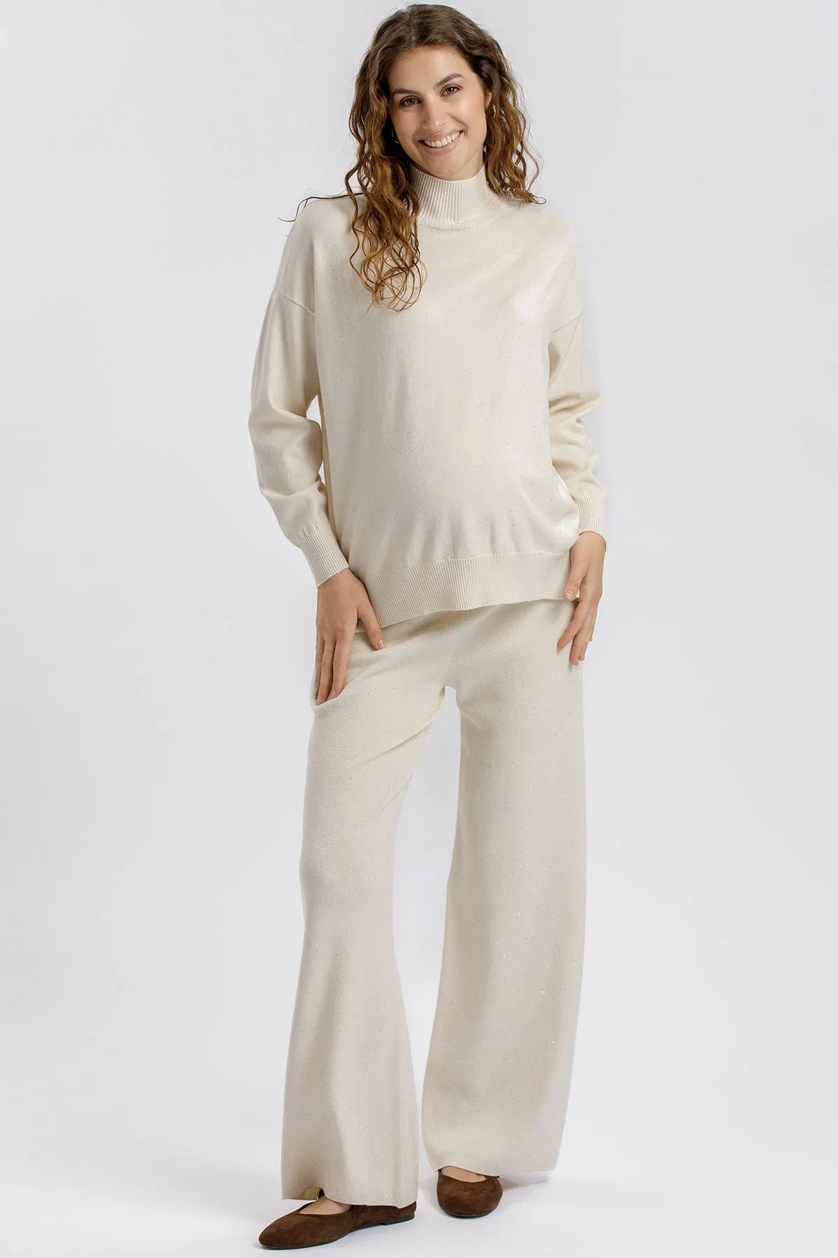Maglia premaman crema con collo alto e dettagli luminosi. Vestibilità morbida e rilassata. Perfetta prima, durante e dopo la gravidanza