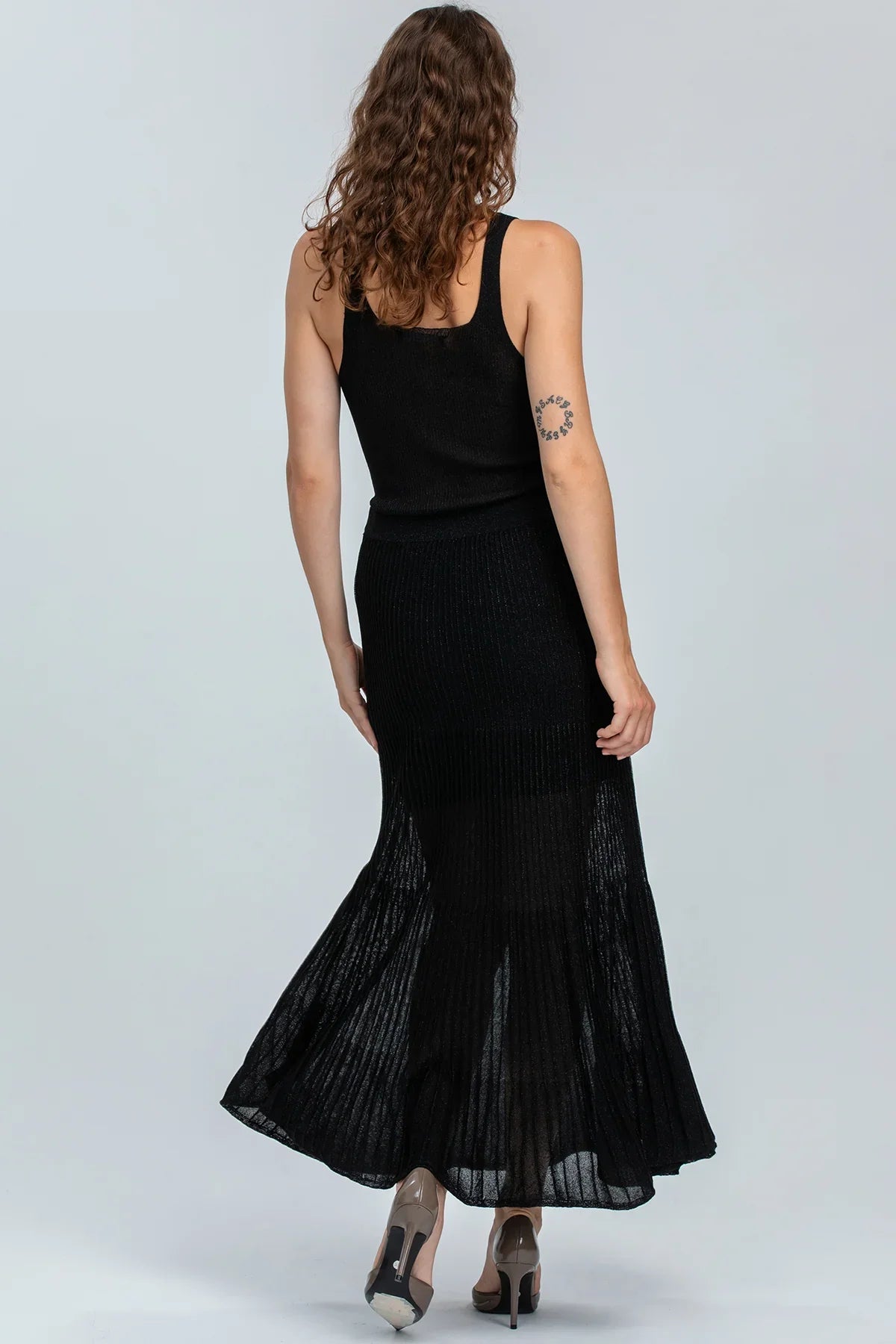 Abbigliamento premaman elegante, donna con abito lungo nero senza maniche, tessuto leggero.