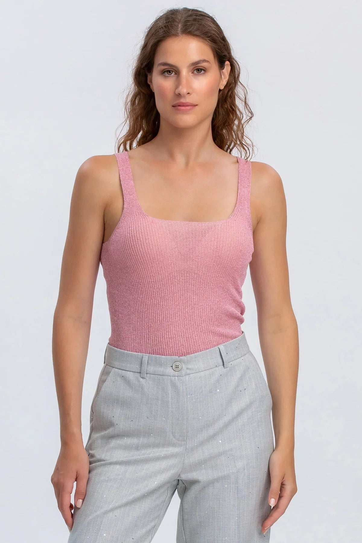 Top premaman rosa smanicato in maglia con pantaloni grigi, abbigliamento maternità elegante