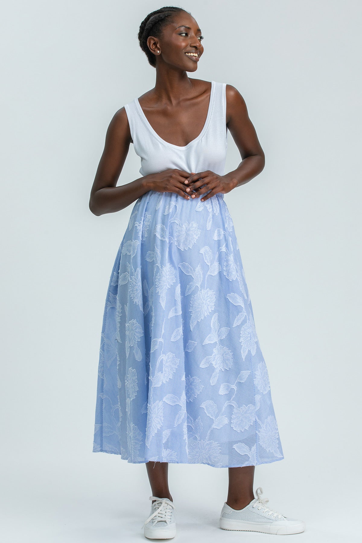 Donna che indossa abito premaman estivo bianco e azzurro con stampa floreale, look confortevole