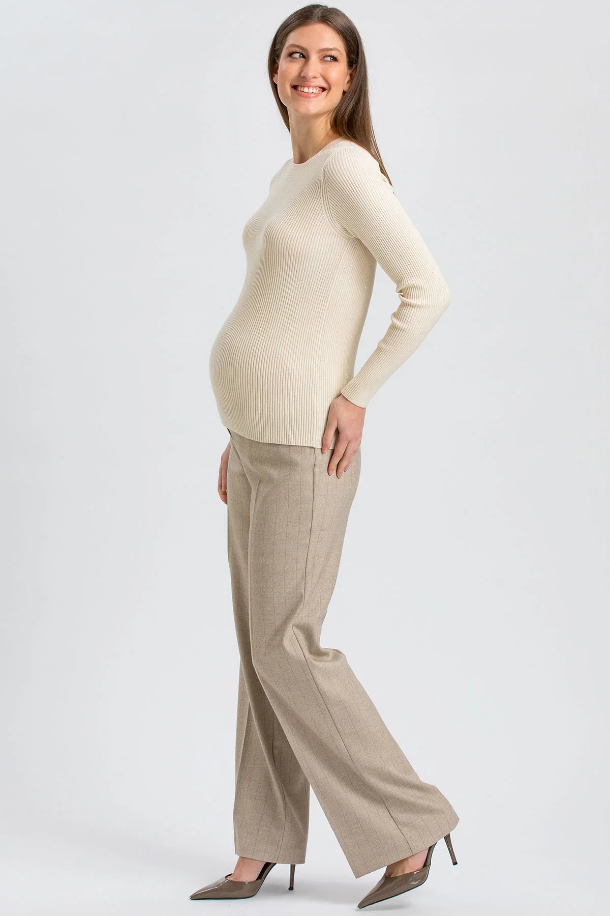 Donna con maglia beige e pantaloni premaman beige a gamba larga di Pietro Brunelli Maternity