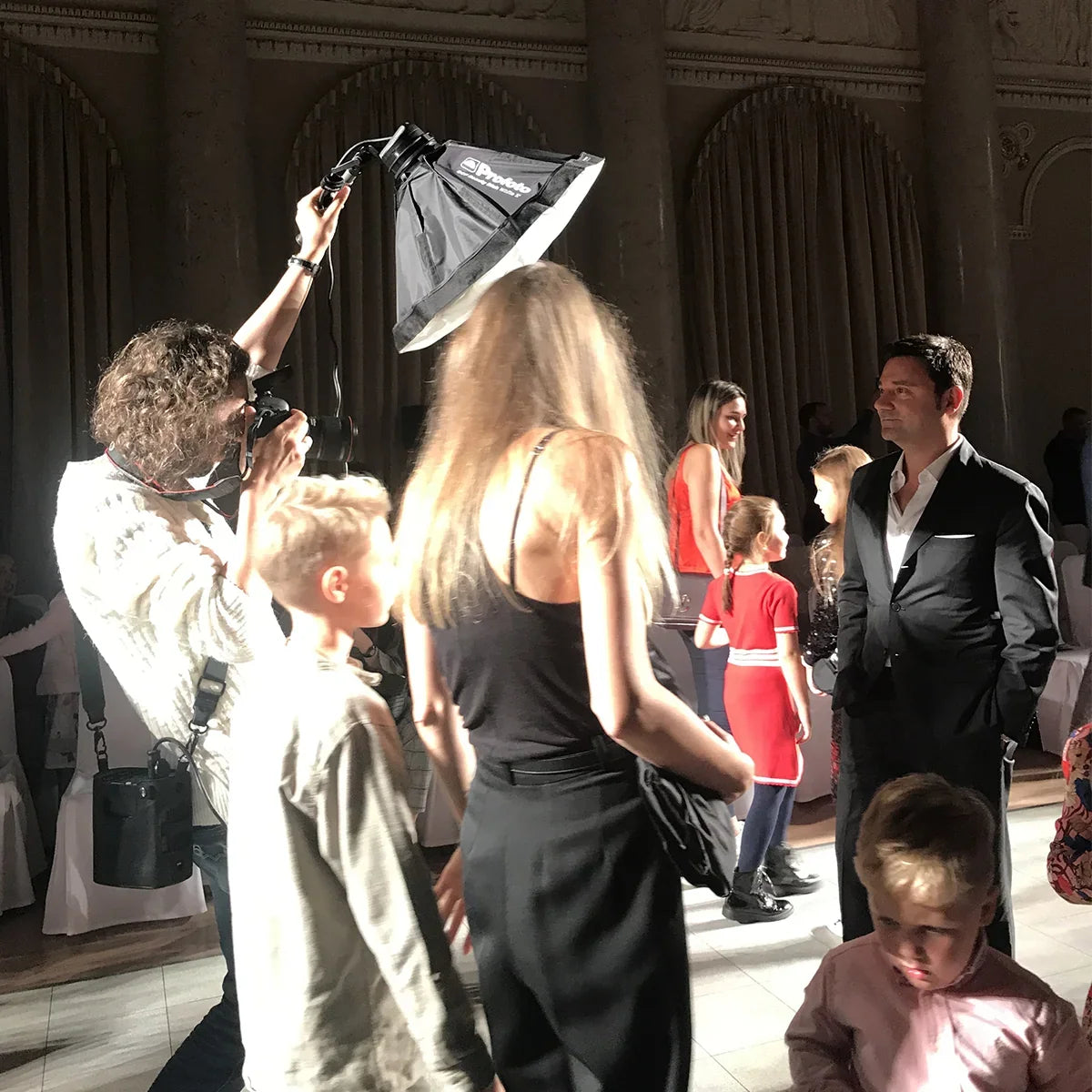 Donna in abito premaman nero e pantaloni premaman neri durante un servizio fotografico.