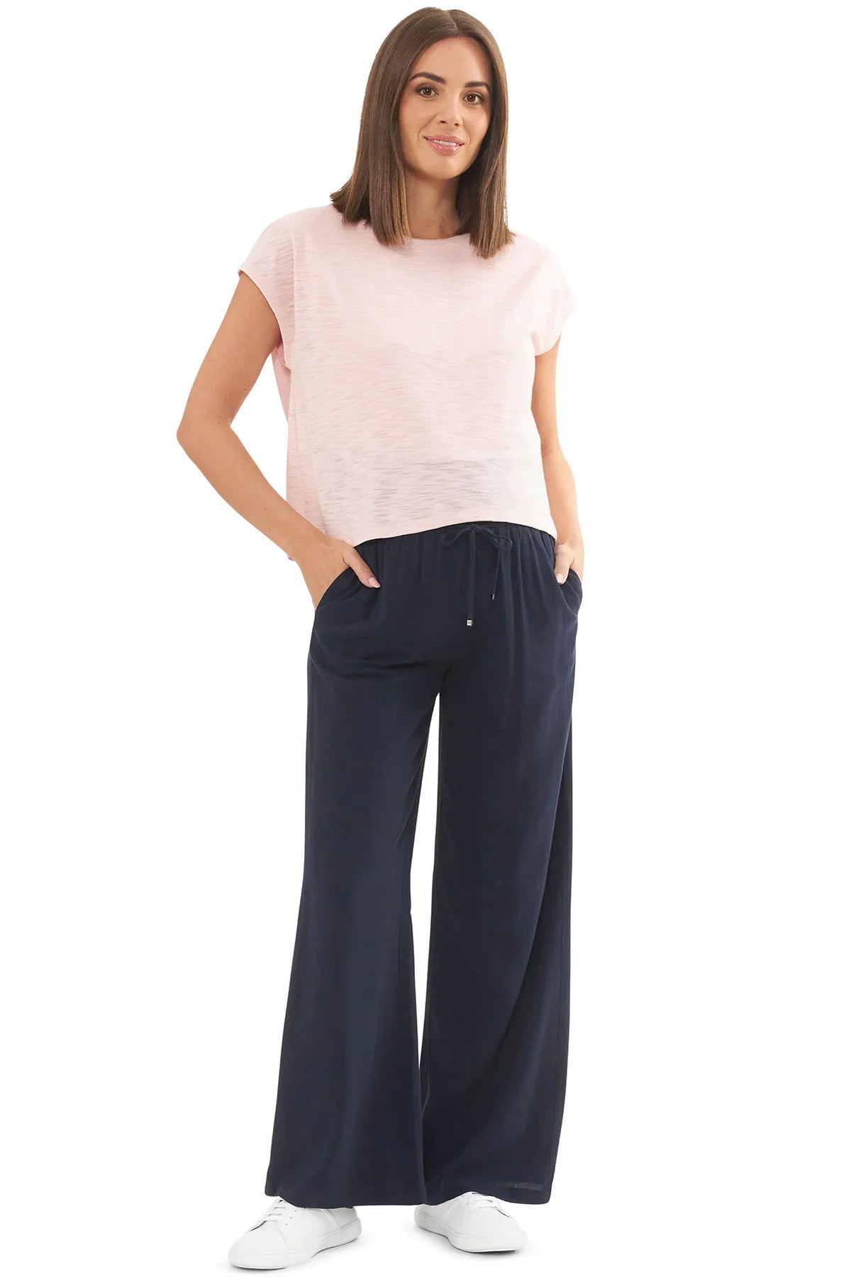 Donna che indossa maglia premaman e allattamento rosa Ripe e pantaloni premaman blu.