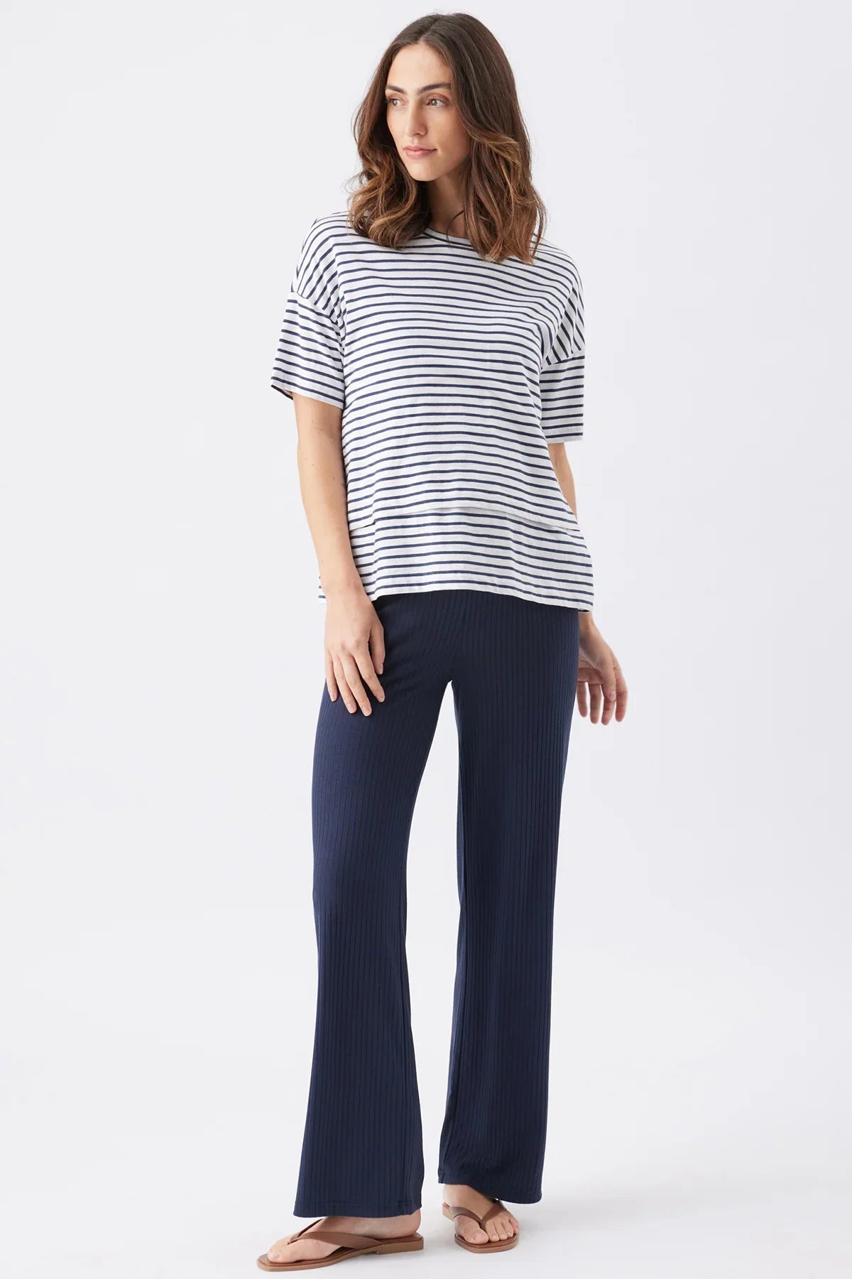 Donna che indossa maglia premaman e allattamento a righe blu Ripe e pantaloni premaman blu.