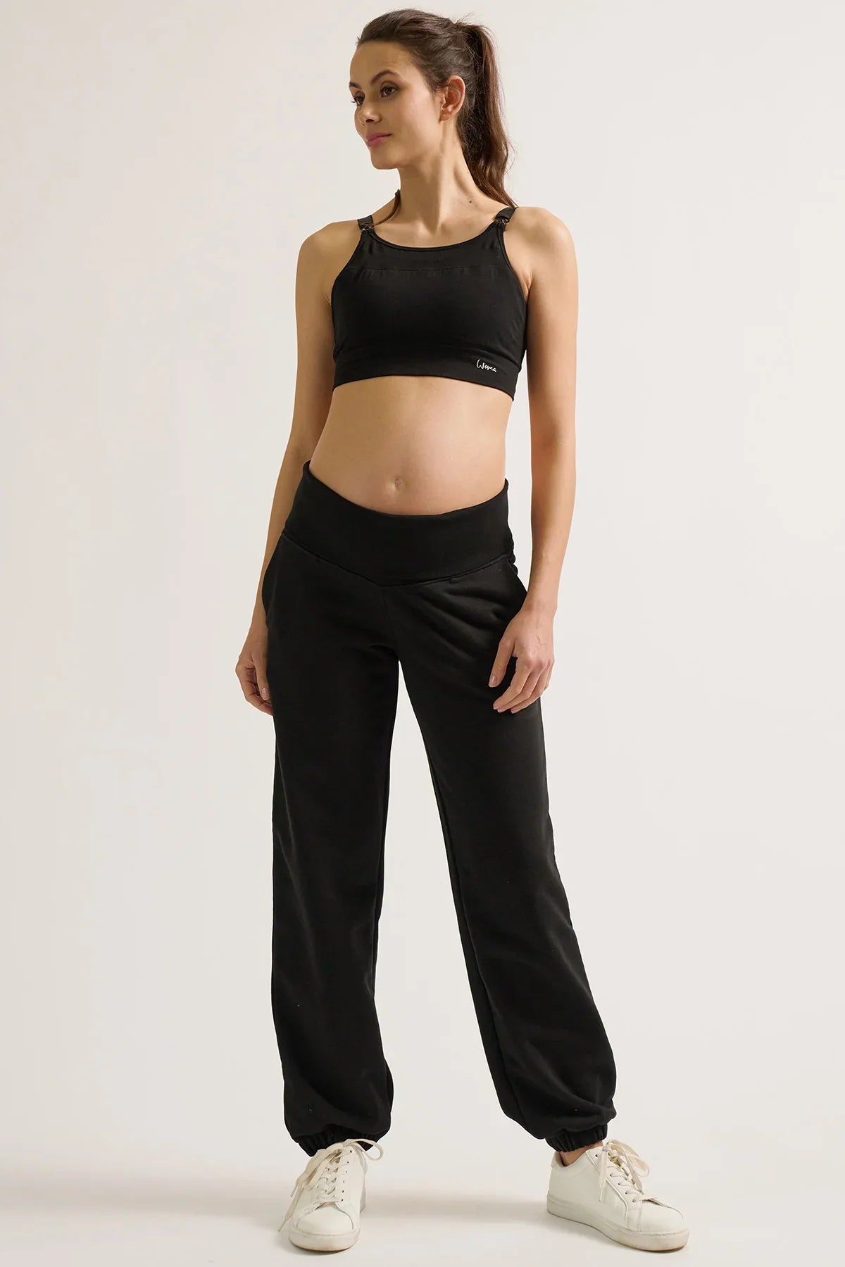 Donna con pantaloni jogger premaman neri Cache Coeur e top sportivo nero