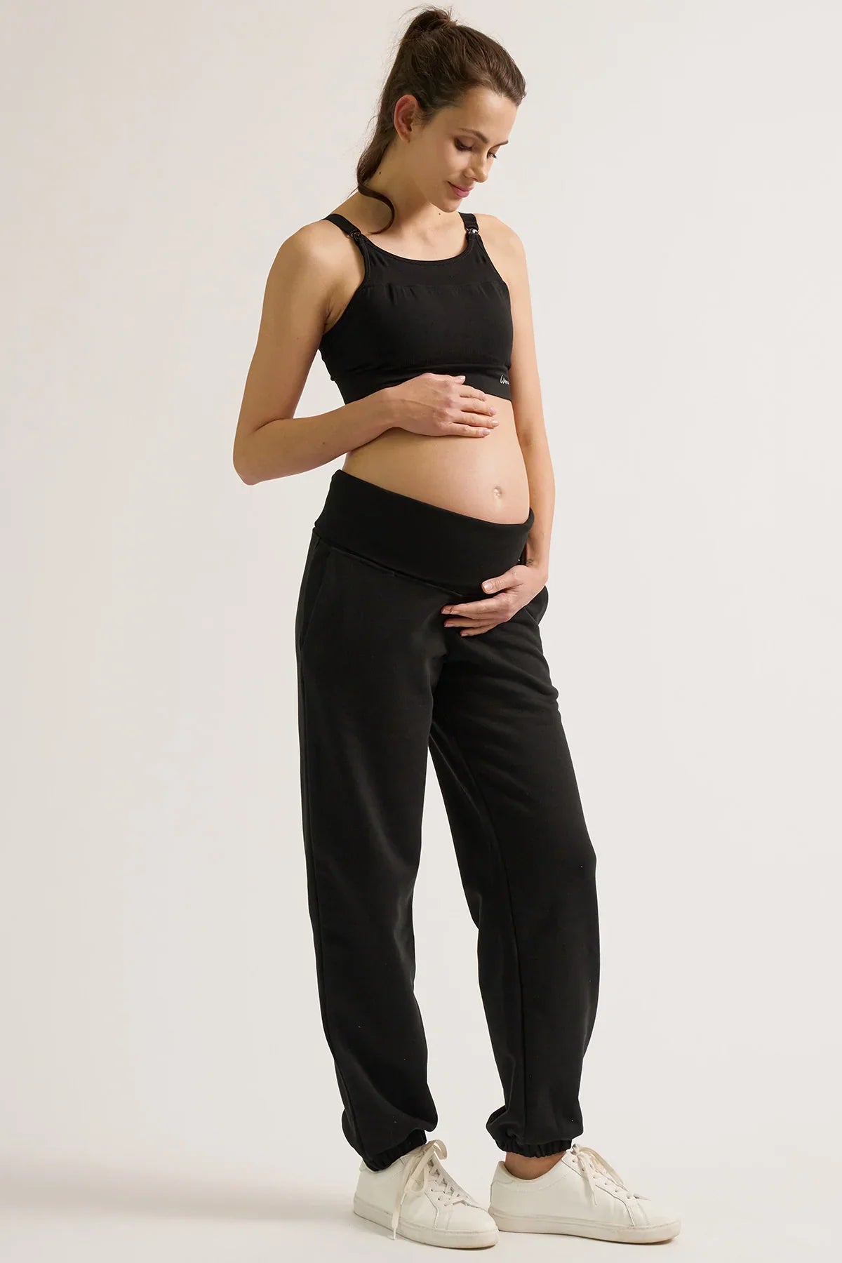 Donna con pantaloni jogger premaman neri Cache Coeur e top coordinato